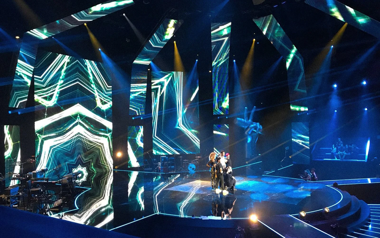 Iconic talent show stage featuring rotating coach chairs with built-in speakers and control interfaces