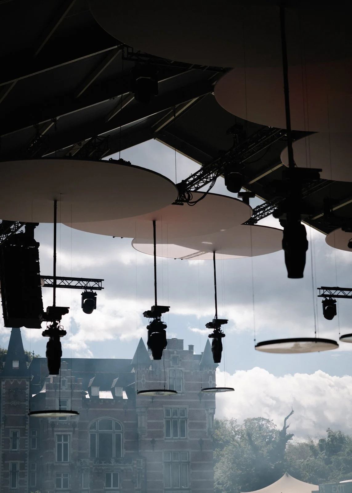 Overhead water basin installation reflecting light across crowd and ceiling