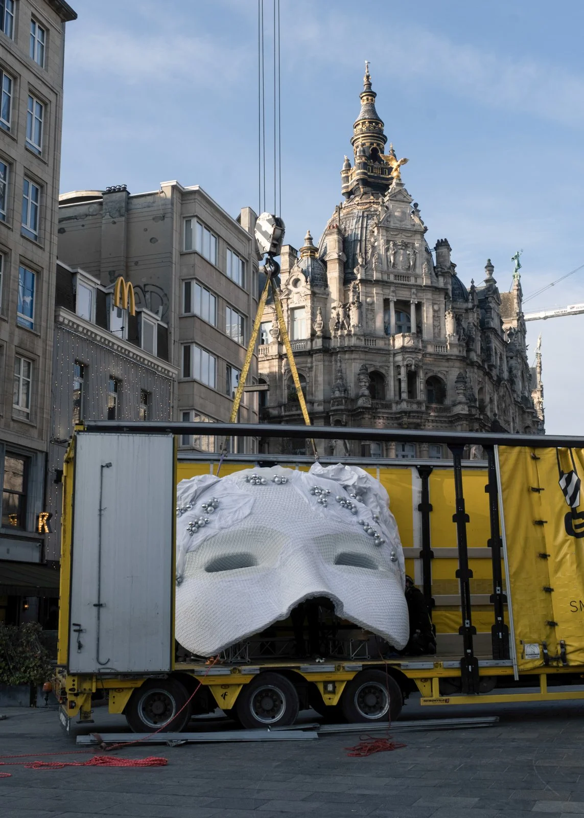 Oversized Bridgerton masquerade mask installation on billboard in city center