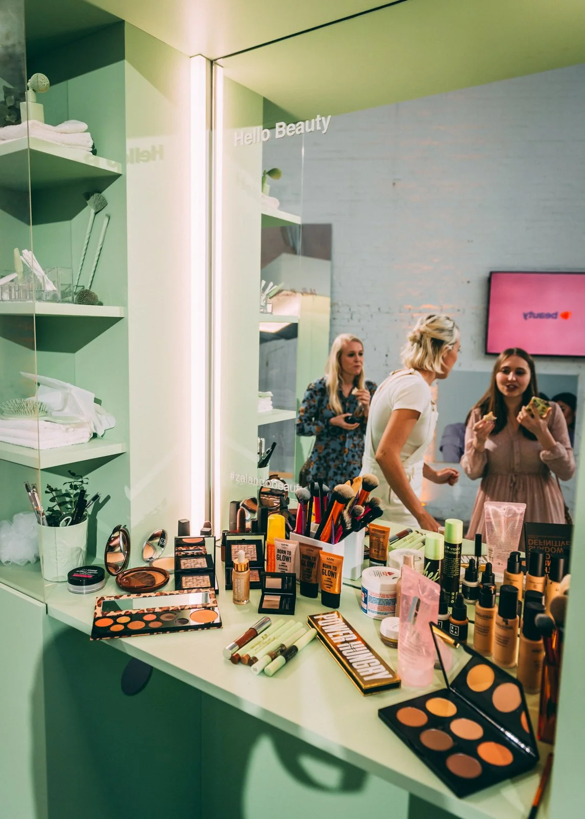 Experiential beauty booth design blending custom furniture, vinyl flooring and lighting into immersive brand environment