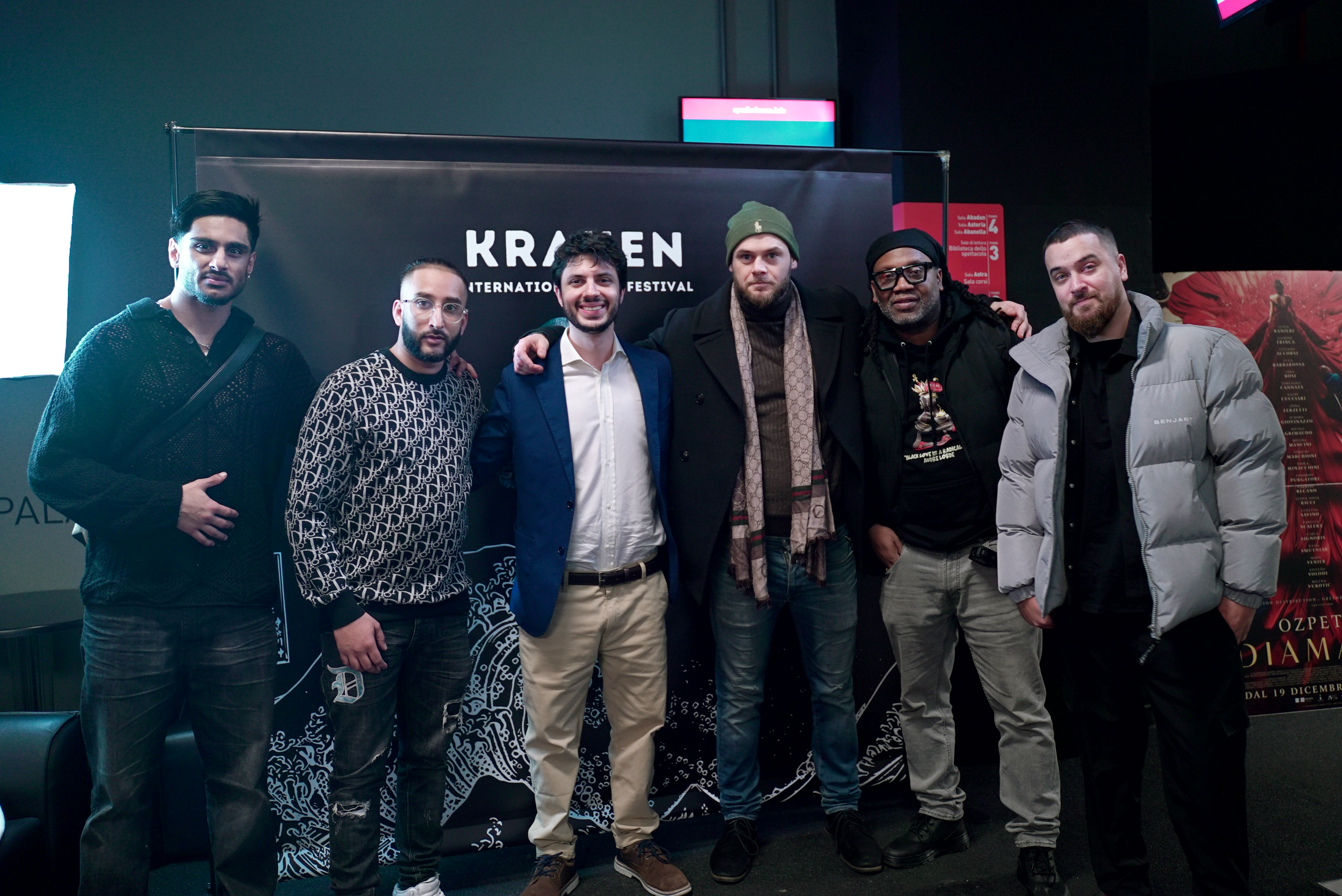 Group of six men standing together in front of a backdrop for Kraken International Fantastic Film Festival.