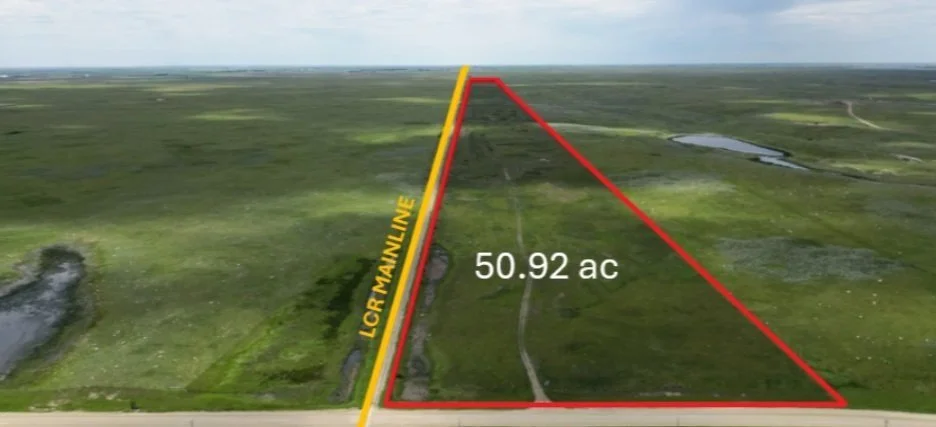 Aerial view of a large plot of land measuring 50.92 acres, outlined in red. Labeled "LGR Mainline" along a yellow boundary line. The landscape features grass and small bodies of water, with a road at the bottom of the image.