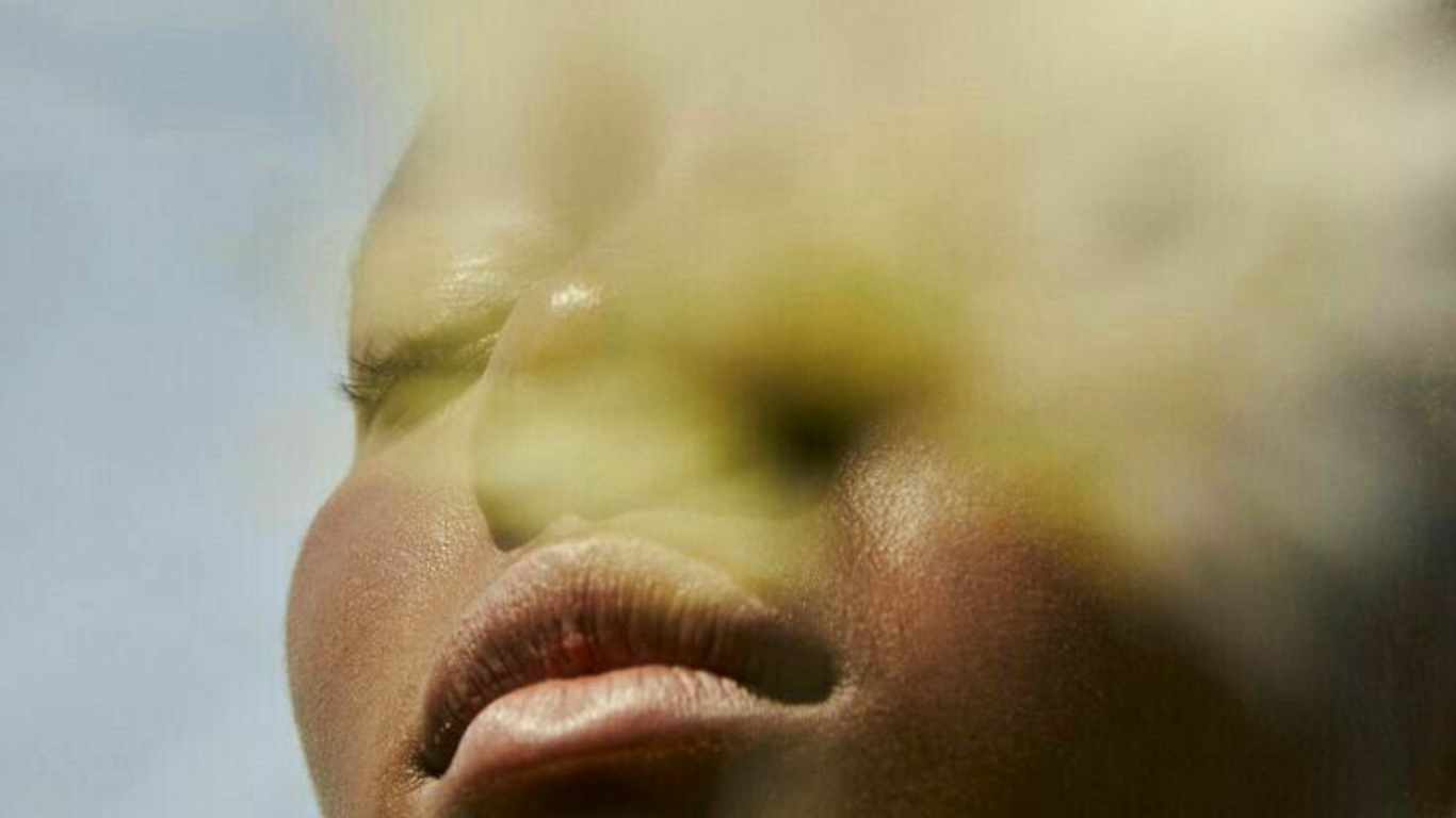 Woman soaking in the sun behind a flower