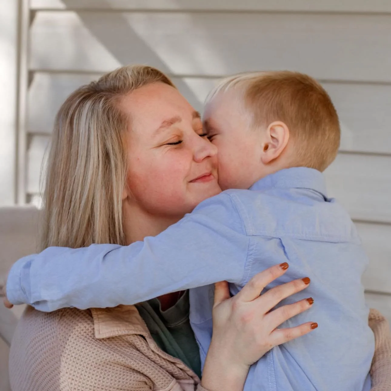 Social media manager and website designer hugging her son in a heartfelt photo moment.