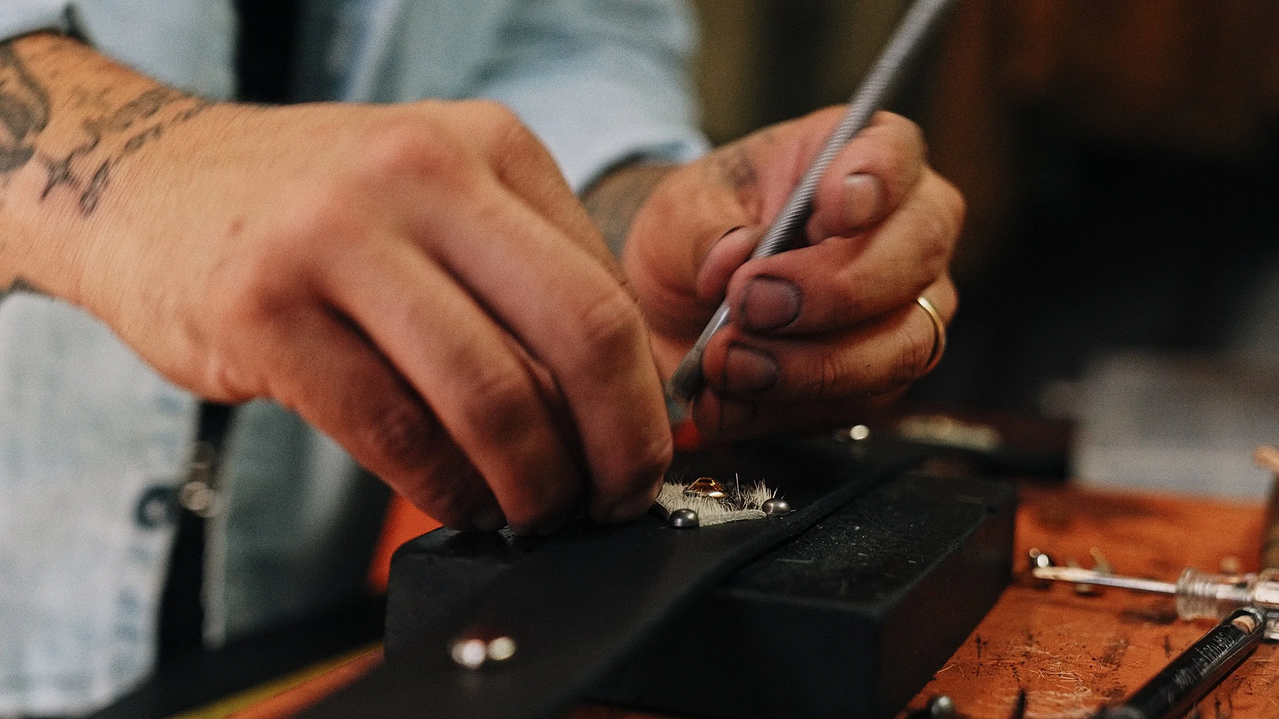Man's hands stamping studs into a leather belt. Image still from Episode 003 of Hands On...with Moonstone featuring Austin from The Belt Daddy