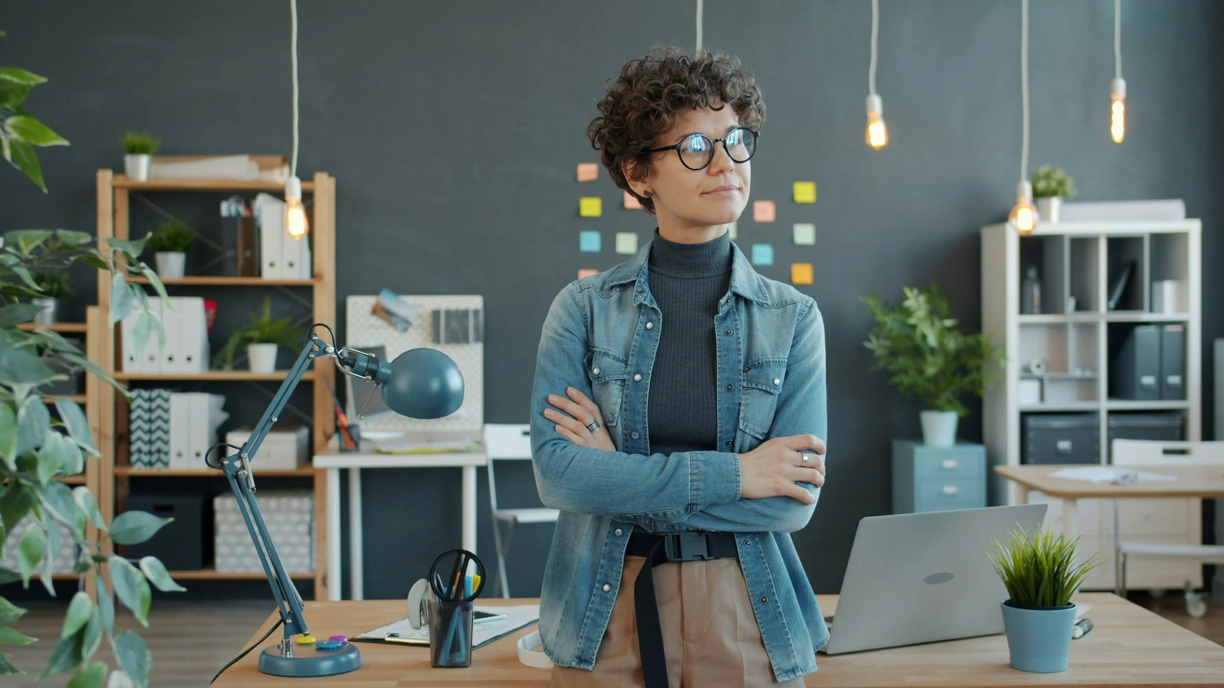 A woman business owner standing in front of her desk at her office; image promoting blog post: "Business Succession Planning for Canadian Entrepreneurs"