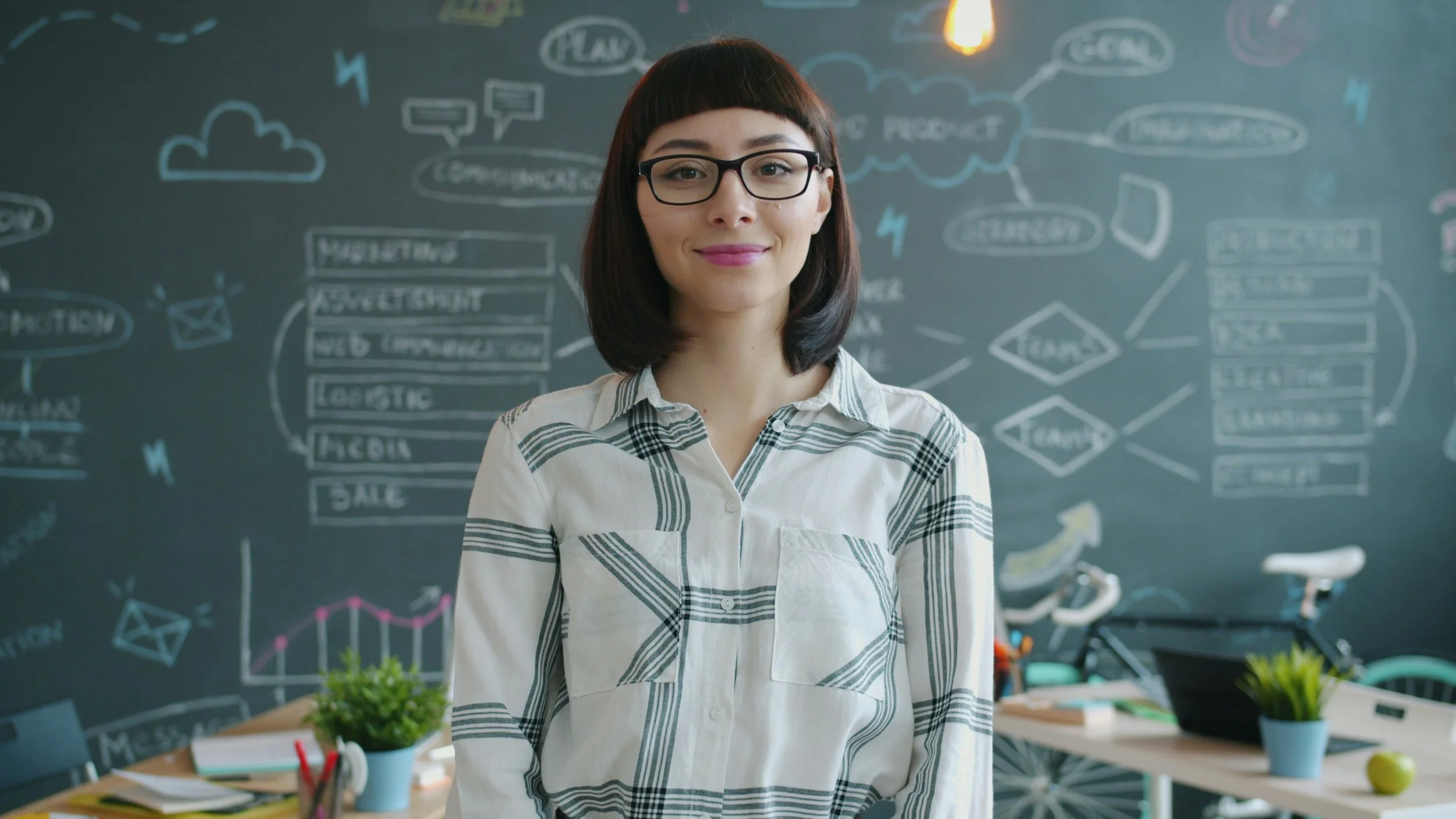 Women entrepreneur standing in the middle of the screen with a blackboard covered with business planning ideas; image promotes blog post: "Executor Responsibilities When a Business Owner Dies"