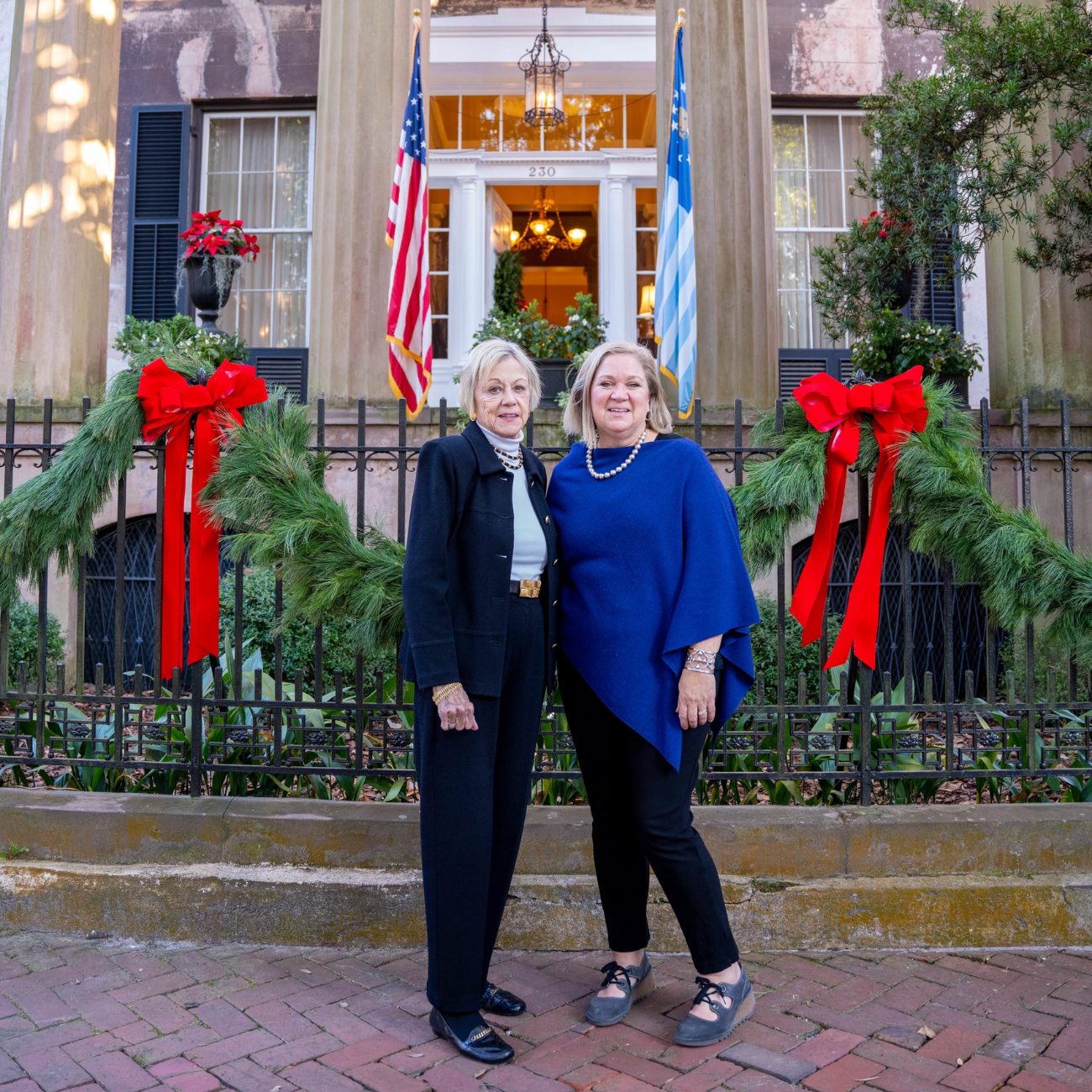 Two women standing in front of a house decorated with Christmas , in Savannah, Georgia