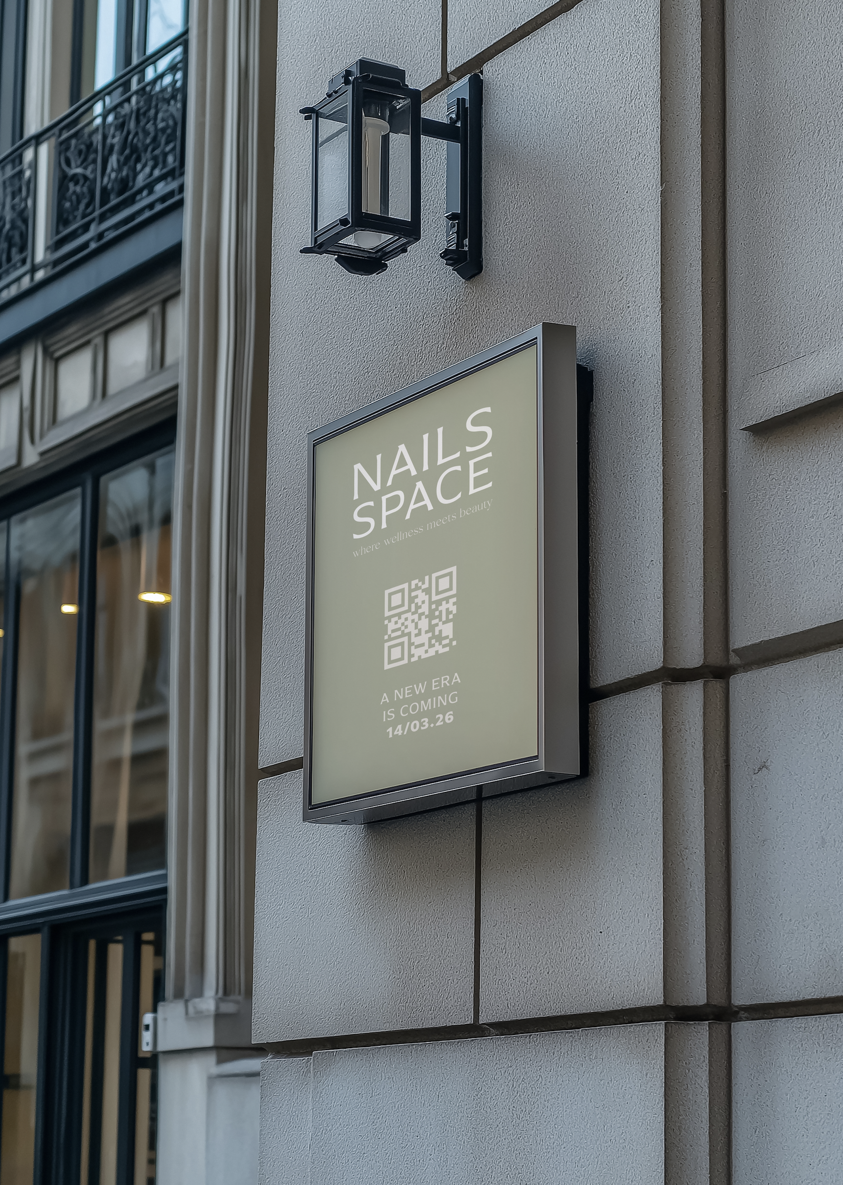 Outdoor sign for Nails Space with a QR code, caption about a new era coming on 14/03/26, mounted on a beige building exterior wall next to a window with black wrought iron balcony.