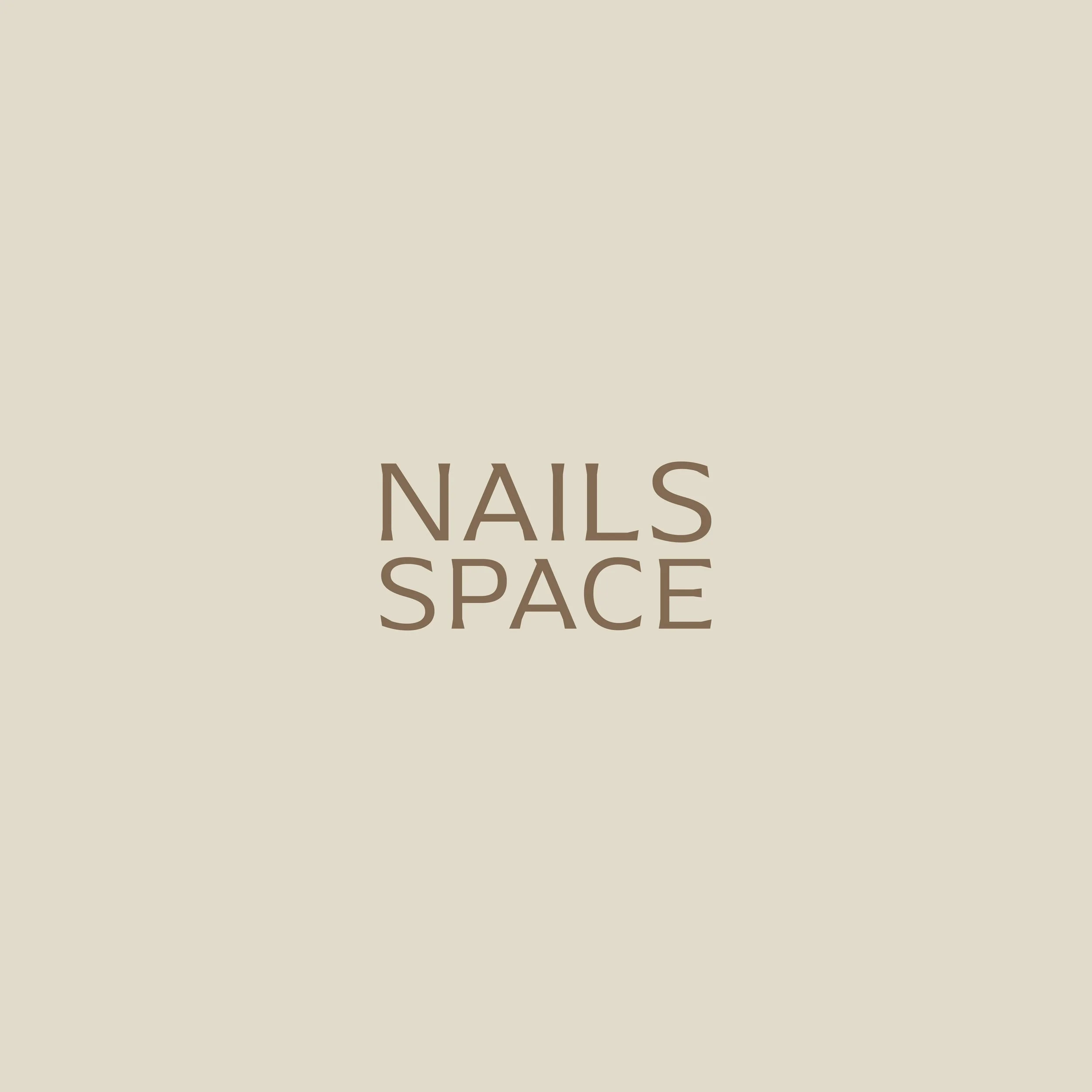 Partial view of a sign with the words "NAILS SPACE" in brown text on a beige background.