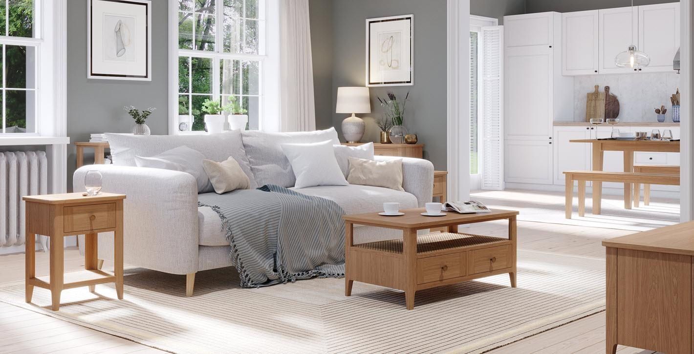 Living room with white sofa, wooden tables, and large windows in a bright, airy space.