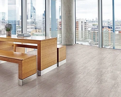 direct flooring suppliers of driffield, commercial flooring, Modern office space with large windows, a wooden table, benches, a plant, and cityscape view
