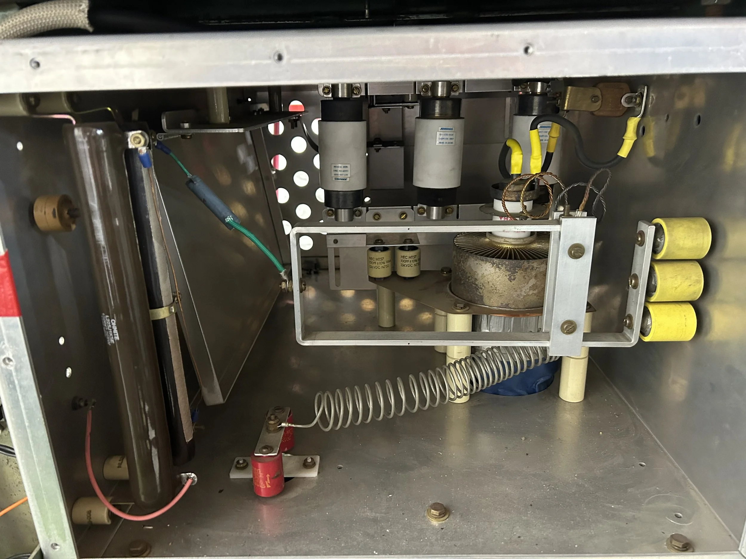 Interior view of an RF welder tube cavity showing components like capacitors, resistors, wires, and metal framework.