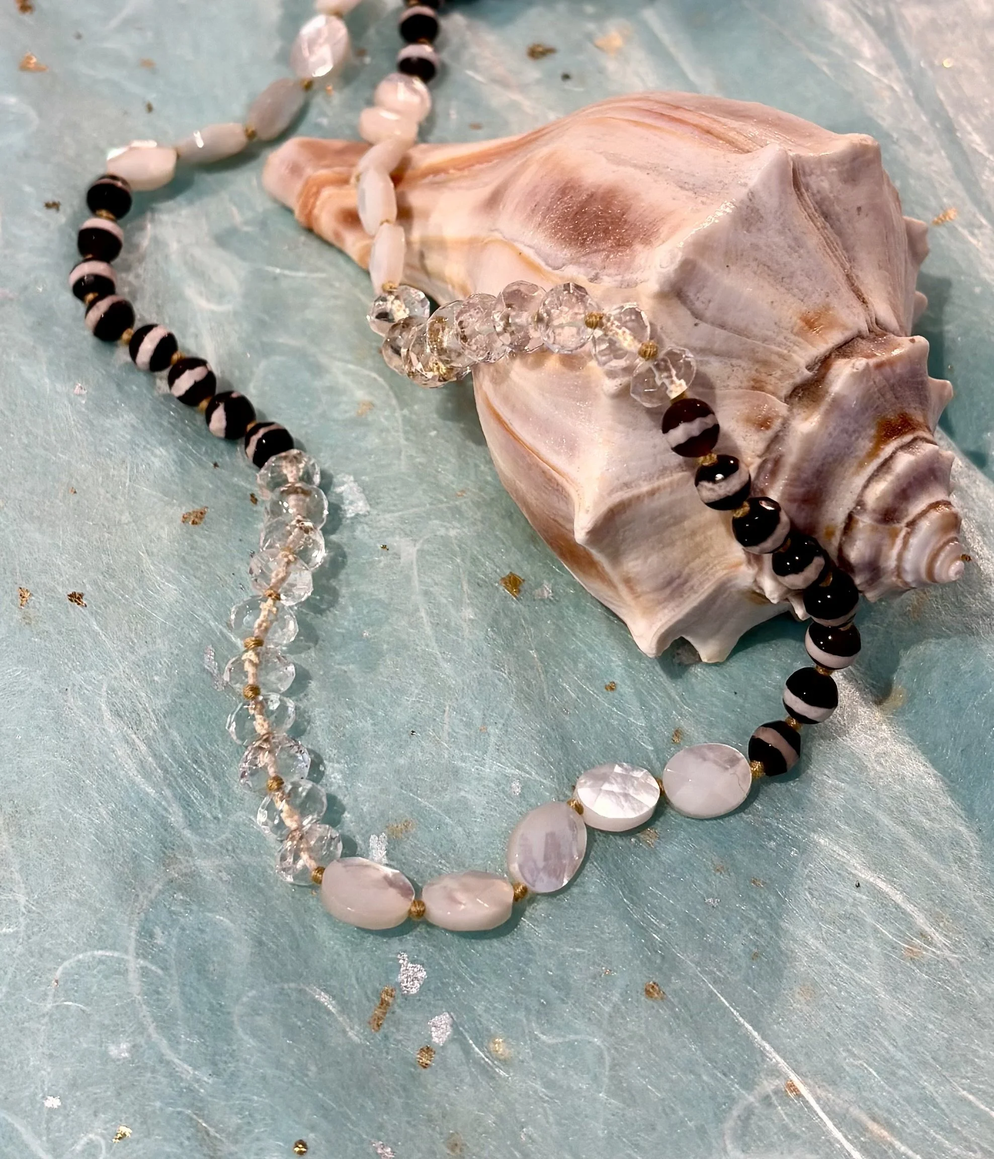 Interior display with folded shirts, glass sculpture, decorative items, clothing rack, and built-in coffee machine.