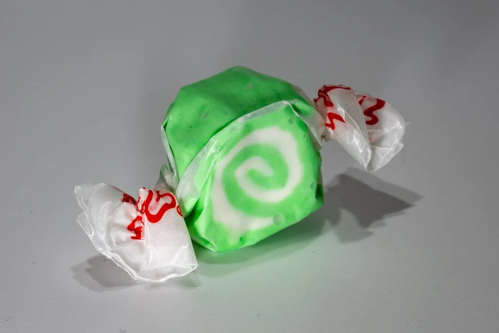 Green and white swirled key lime saltwater taffy from Sea Bird Gifts & Candy in Westport WA. Bright taffy wrapped in wax paper with a citrusy twist.