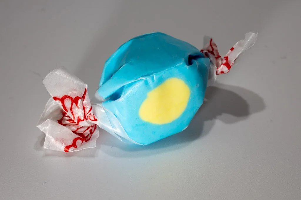 Bright blue and yellow passion fruit saltwater taffy from Sea Bird Gifts & Candy in Westport WA. Eye-catching taffy wrapped in white wax paper with red design