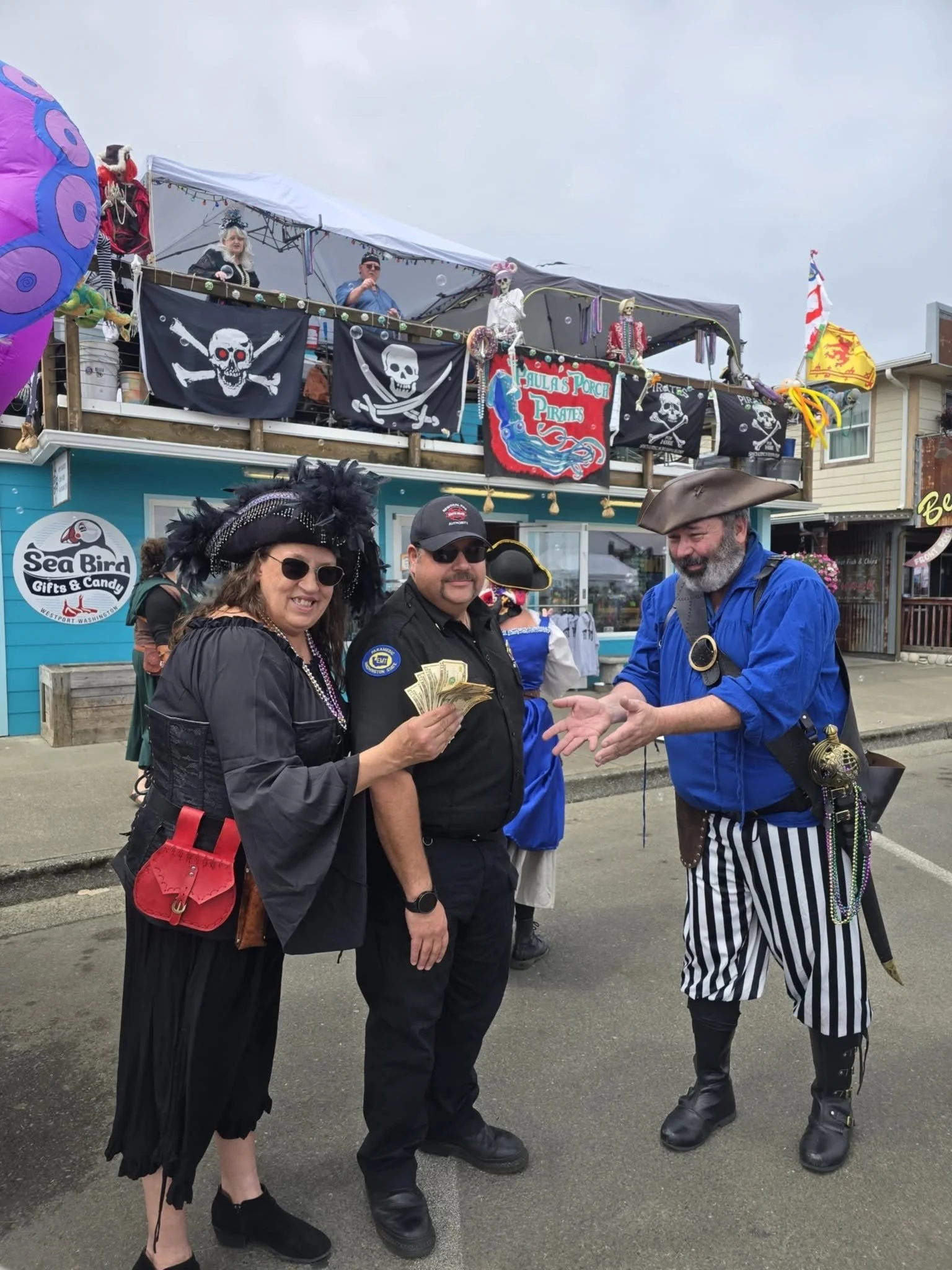 a couple people dressed as pirates handing out cash money to a lucky winner