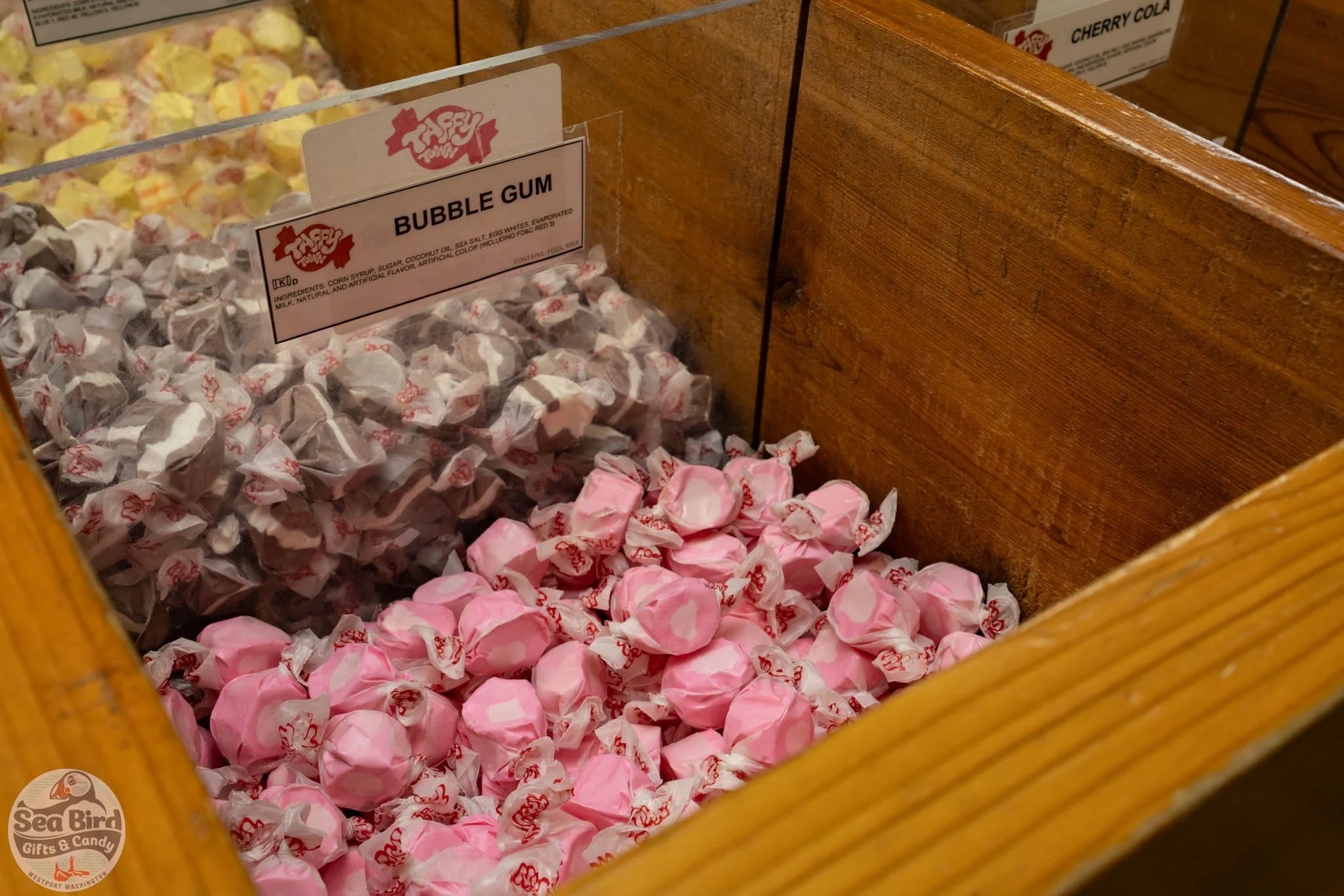 A display box of assorted bubble gum candies, with pink and white wrappers, at Sea Bird Gifts & Candy store.