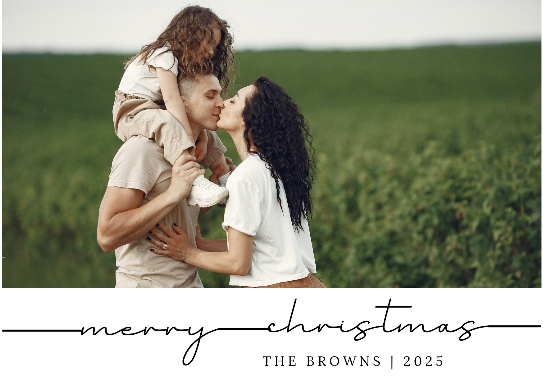Family in field with child on parent's shoulders, exchanging a kiss, "Merry Christmas The Browns 2025" text.