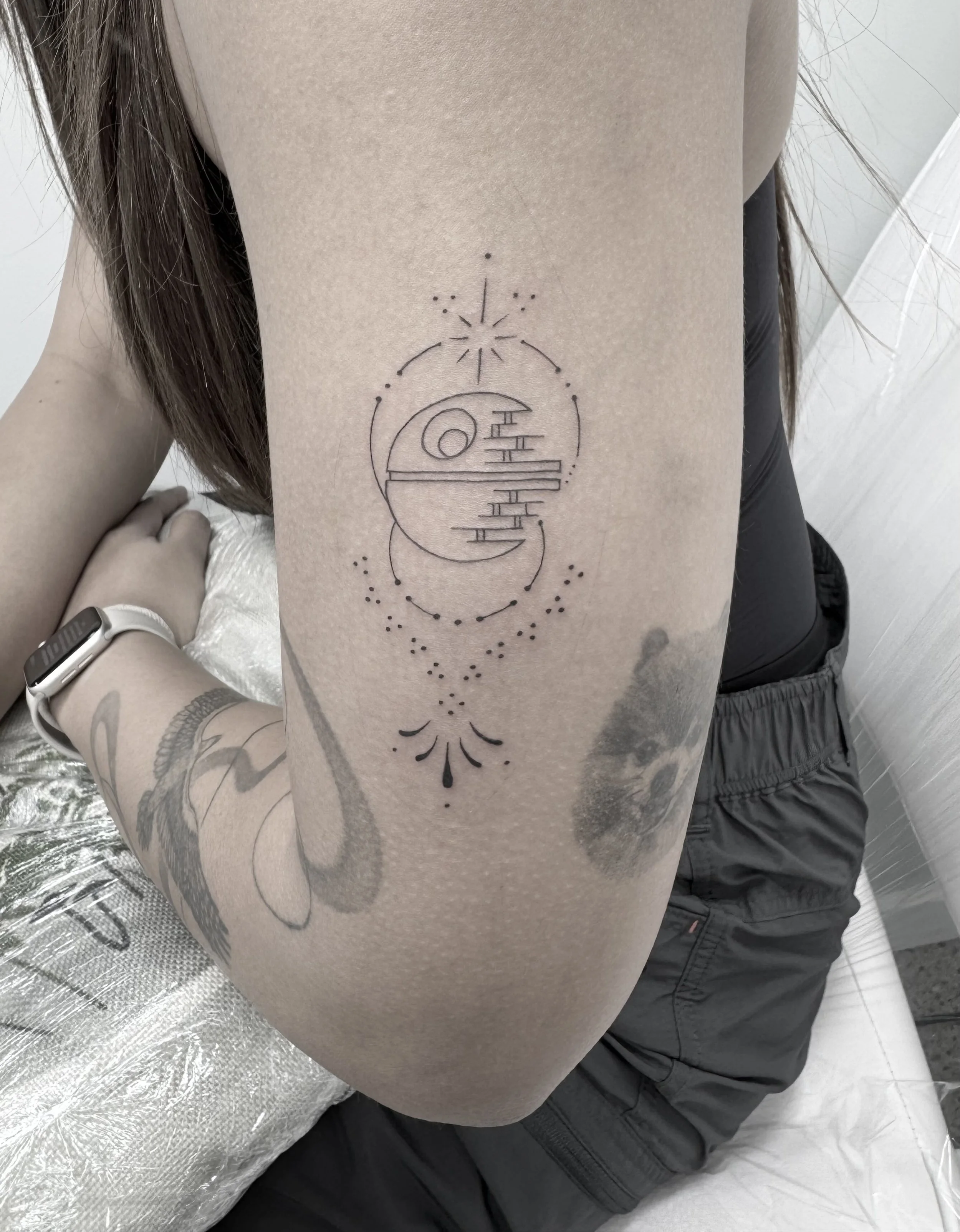 Fineline ornamental tattoo of the Death Star from star wars, feminine and done in Queenstown for a flash day in winter.