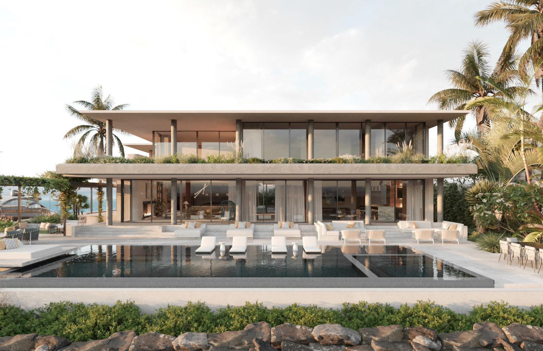 Modern two-story house with glass walls, outdoor pool area with lounge chairs, surrounded by greenery and palm trees.
