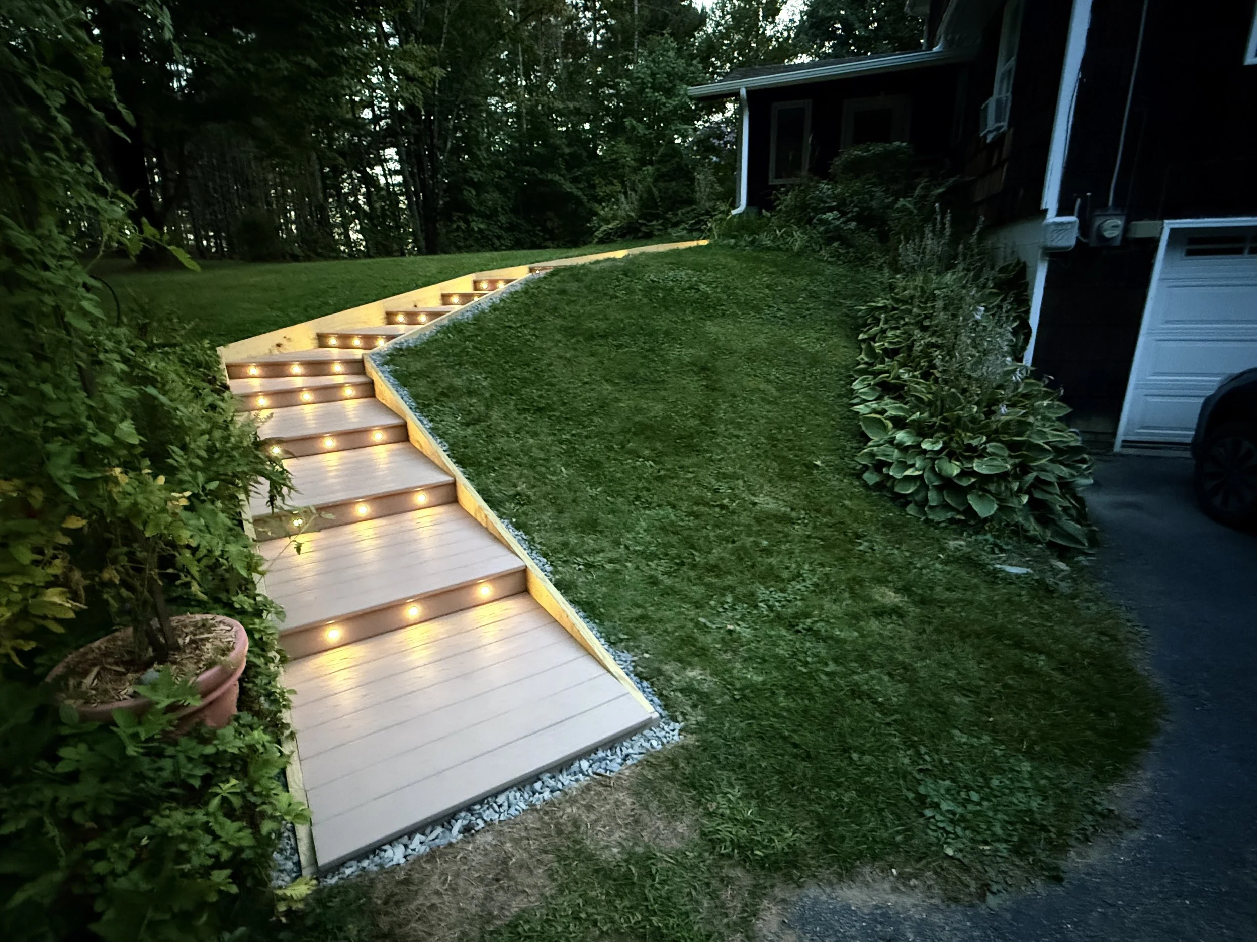 Rebuilt landscape staircase with integrated lighting for safe hillside access in Vermont.