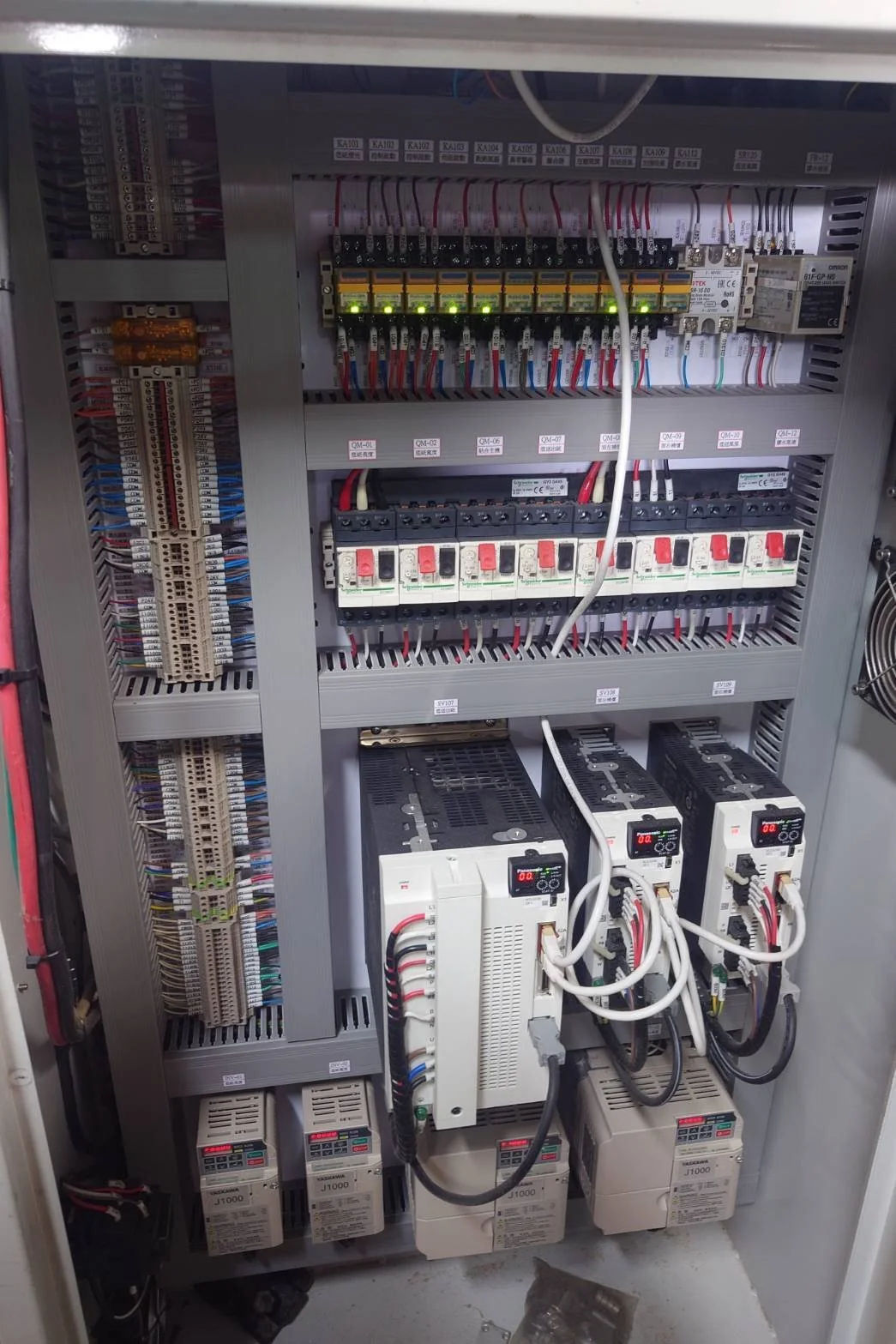 Electrical control panel with various circuit breakers, wiring, and industrial components.