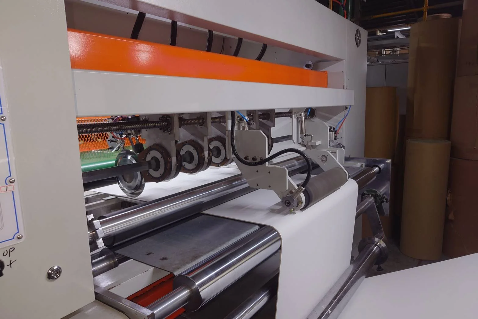 Industrial machine with rollers and gears, appears to be used for manufacturing or printing.