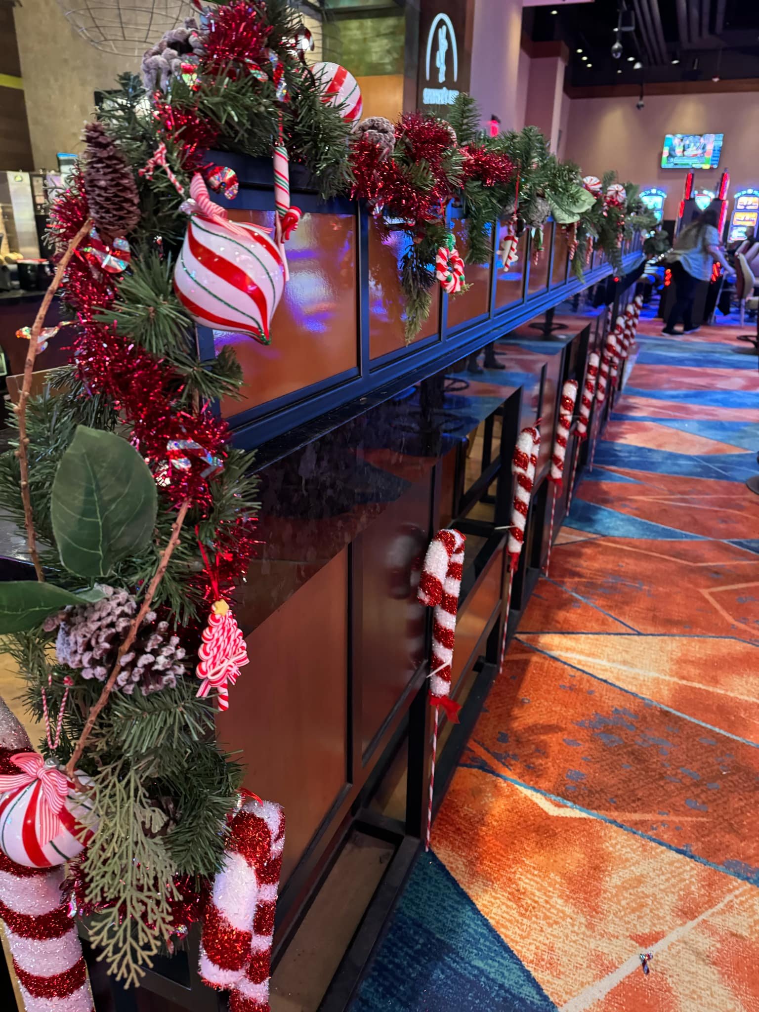 Decorated casino counter with Christmas garland, candy canes, ornaments, and festive decorations.