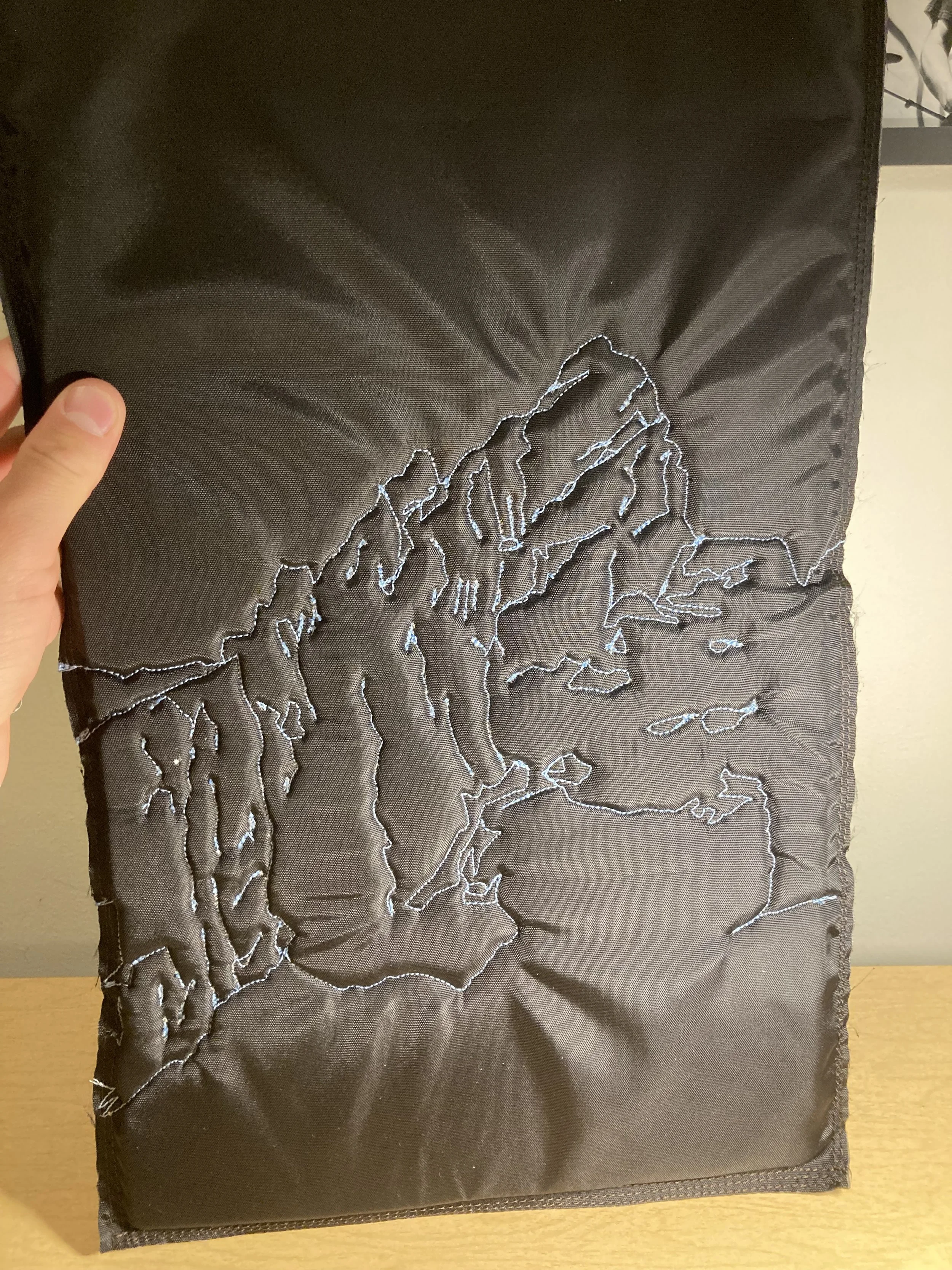 Stitching an outline of the North Face of the Grand Teton into the back panel.