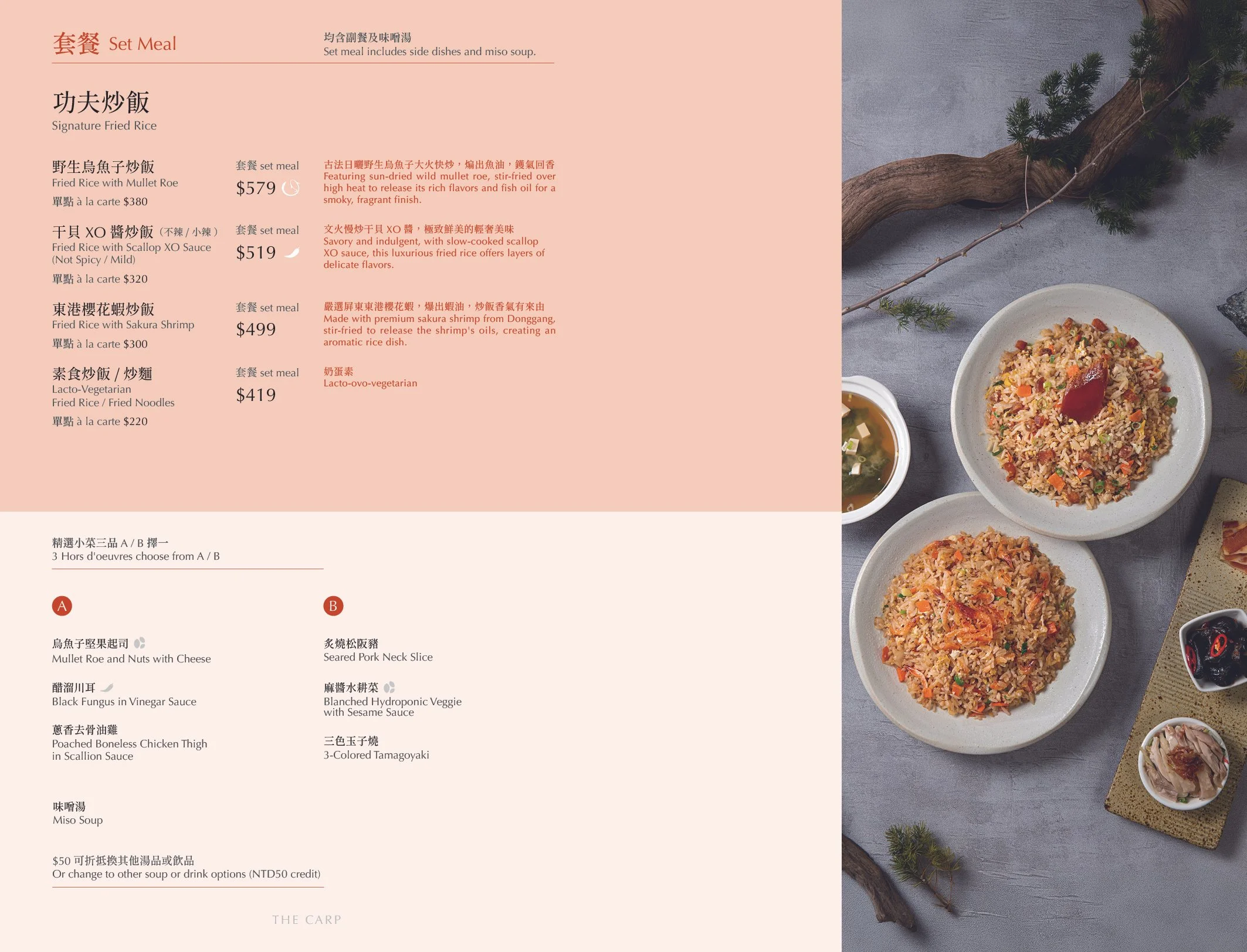 A menu page displaying a set meal selection of fried rice dishes with descriptions and prices, alongside a photo of two plates of fried rice, a bowl of soup, a glass of red wine, and small sides on a gray surface with a decorative tree branch.
