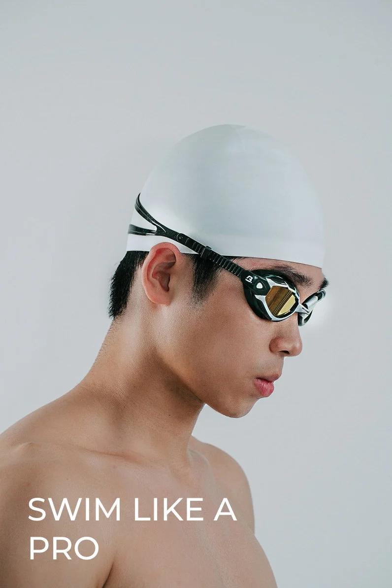 Young man wearing a white swim cap and black swimming goggles, looking down, with the text 'Swim Like a Pro' at the bottom.
