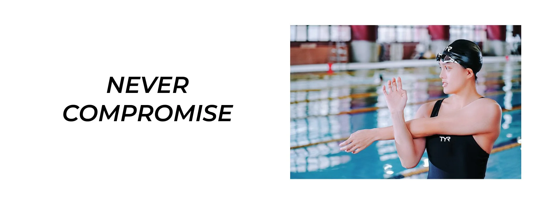 A female swimmer in a black swimsuit and swim cap, standing by the poolside, adjusting her goggles with her right hand, with the pool and lane dividers in the background.