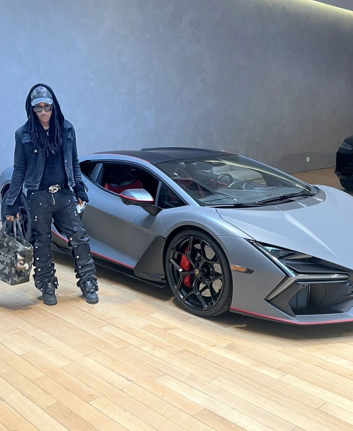 Jusino hairstylist standing next to a luxury car
