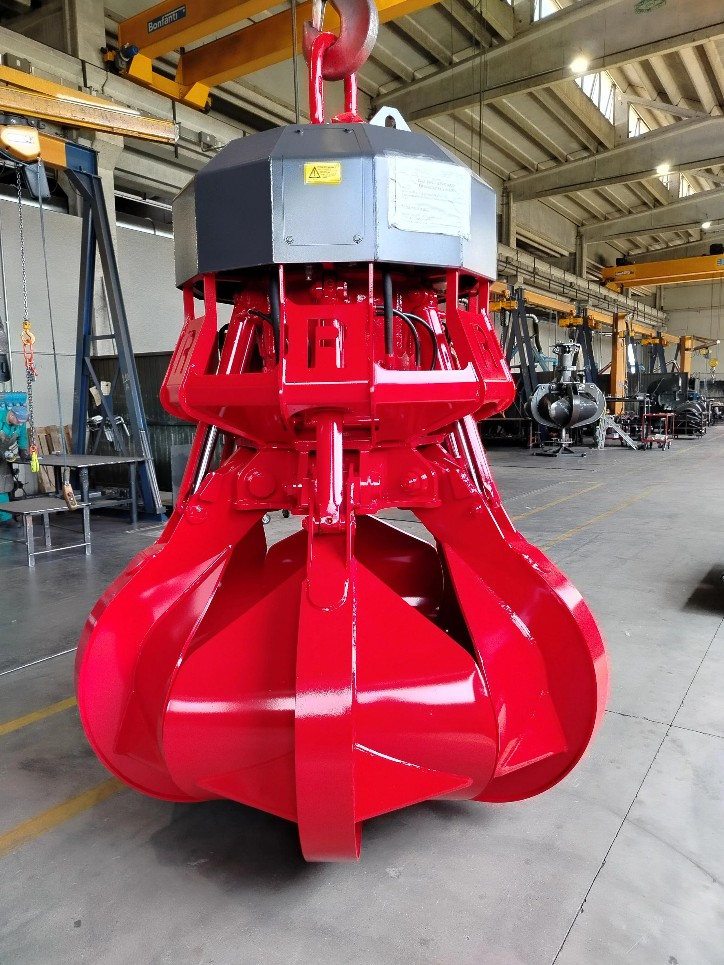 Rozzi ER1800L6PA Electro hydraulic grab. The grab features 6 fingers / fully enclosed tines. Painted in red, this grab is to load an incinerator inside a waste transfer station. 