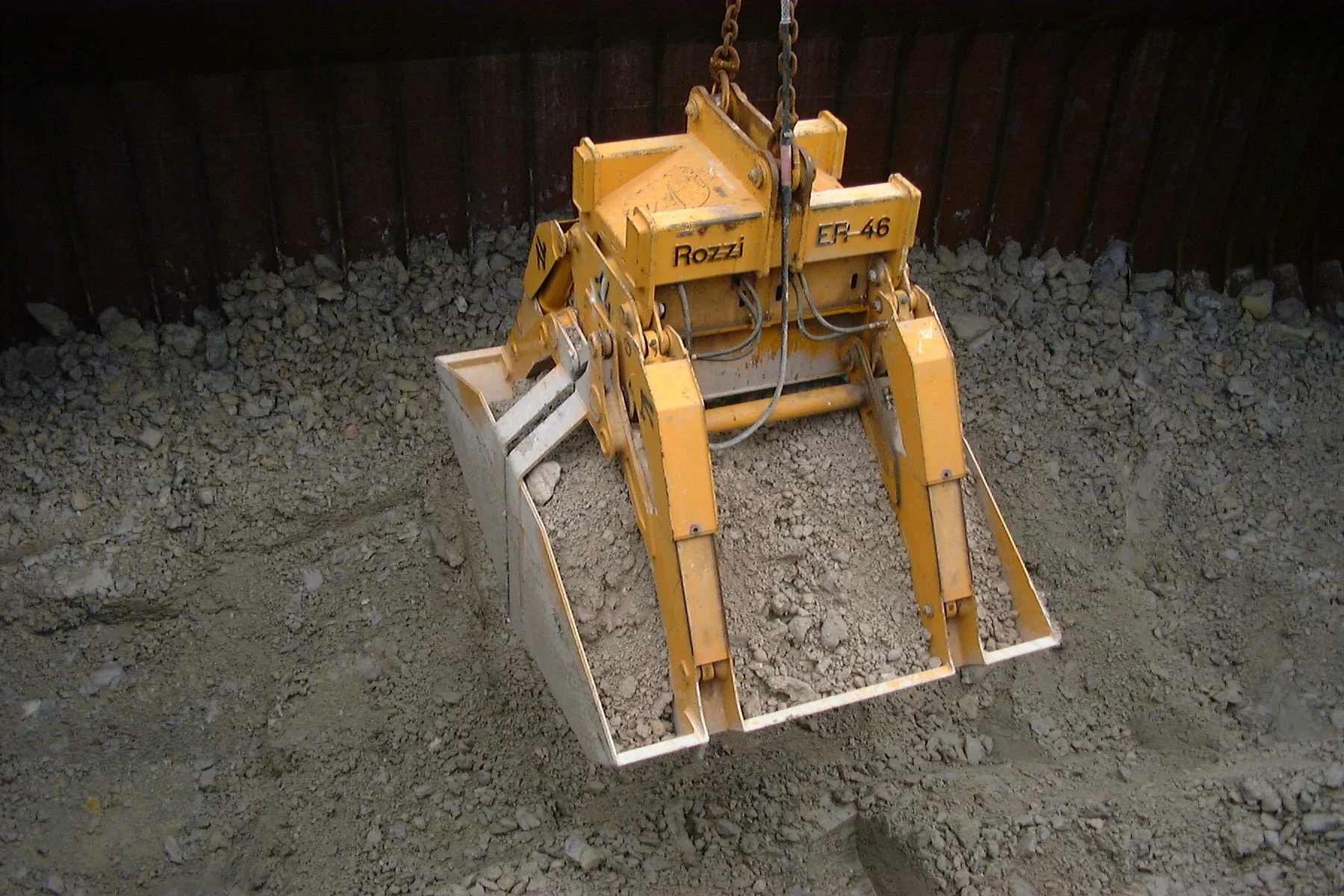 Close-up of a Rozzi Electro hydraulic Clamshell grab unloading sand in a port.