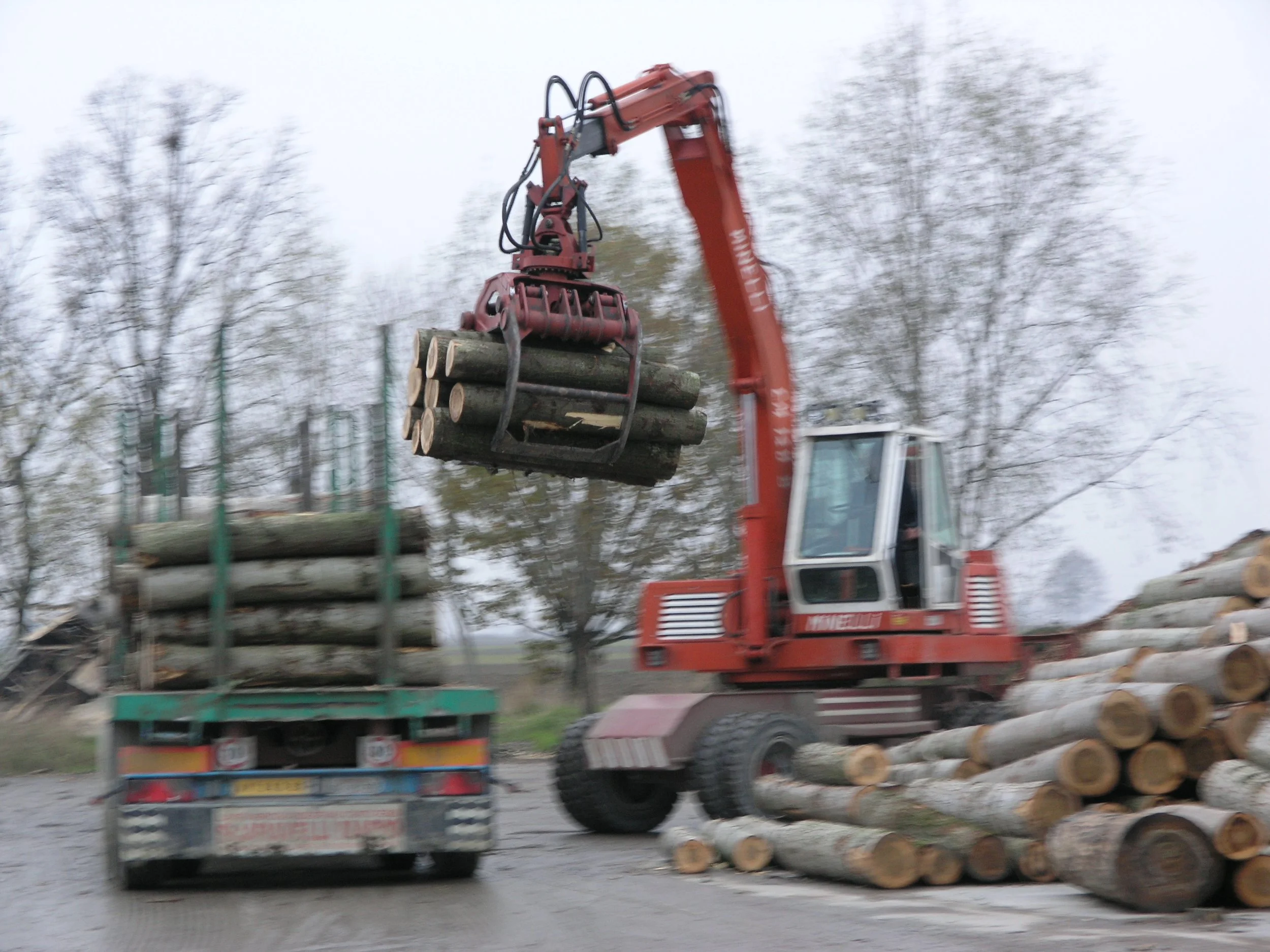 A Rozzi hydraulic log grab in forestry loading onto a flatbed lorry. 