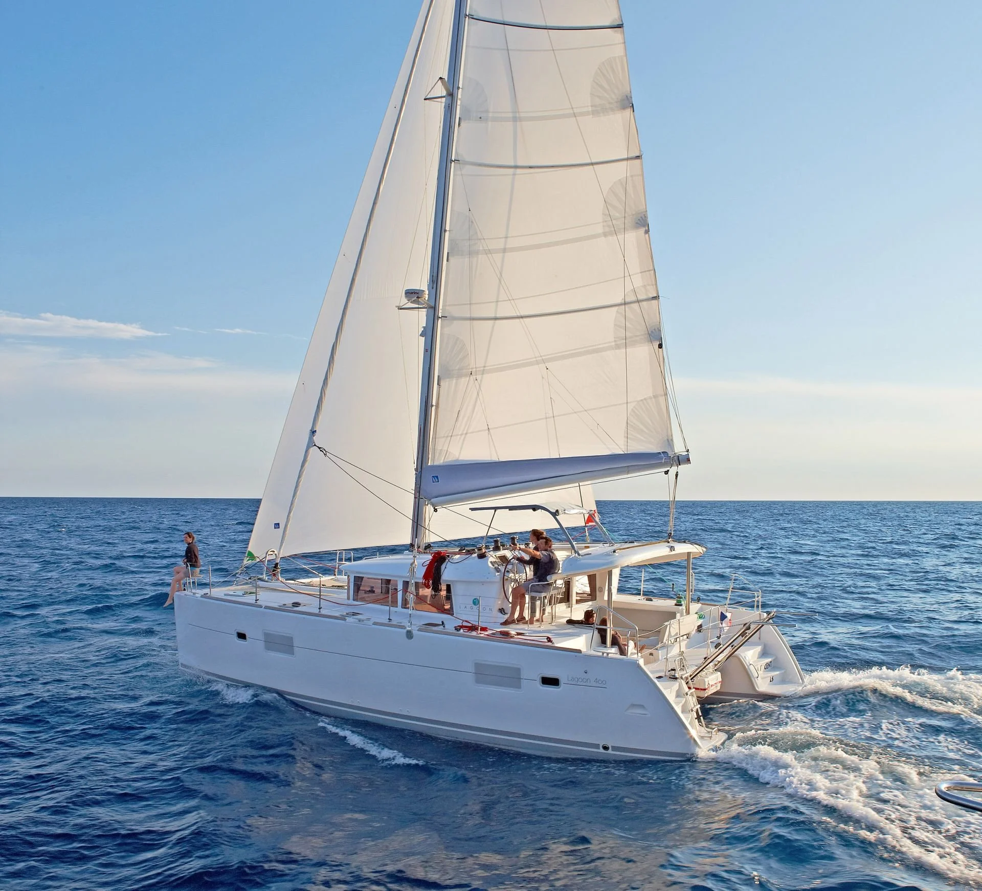 Sailing catamaran along the southern coast of Mykonos with open Aegean Sea views