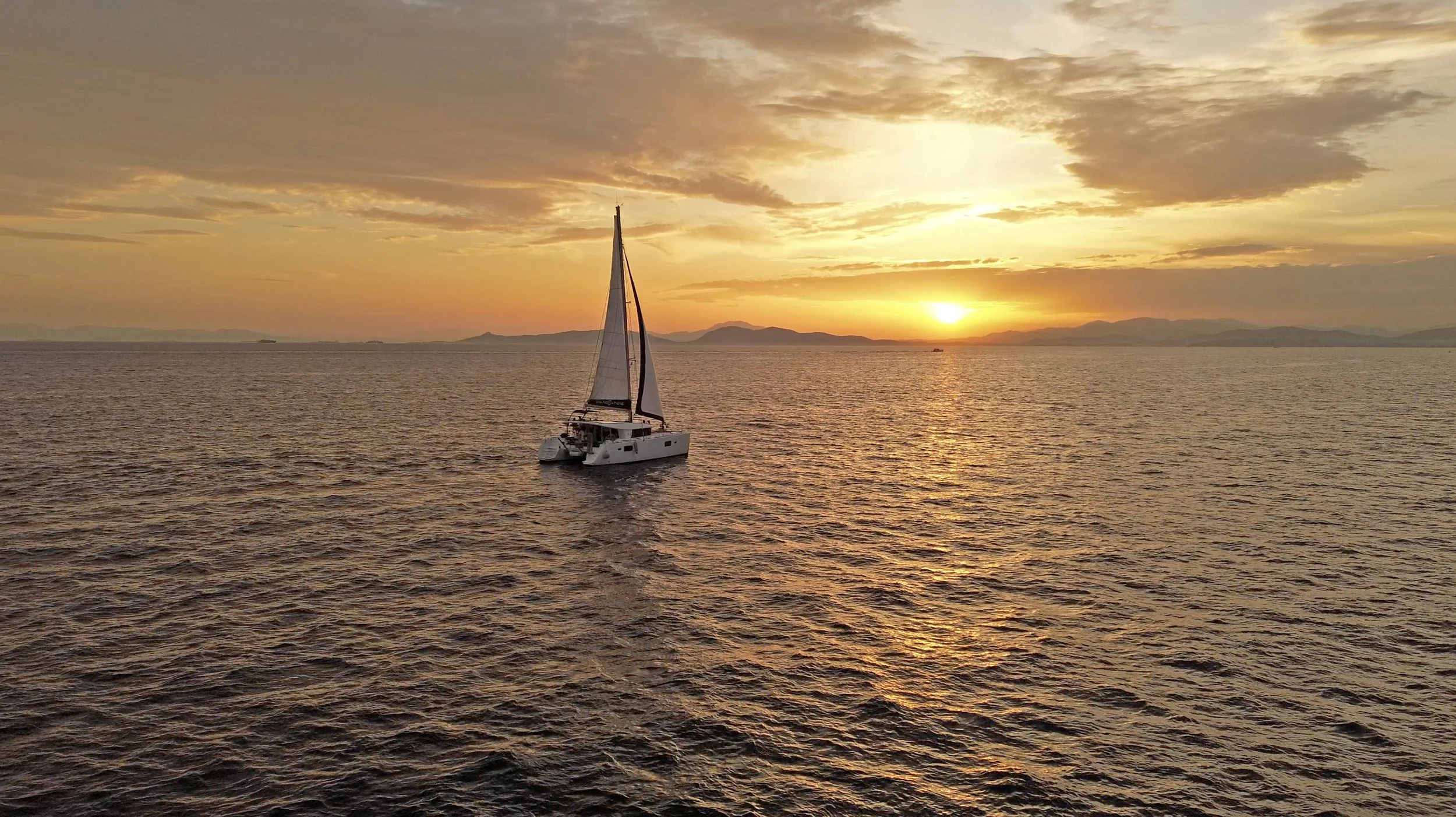 Private catamaran sailing at sunset in the Saronic Gulf near Athens