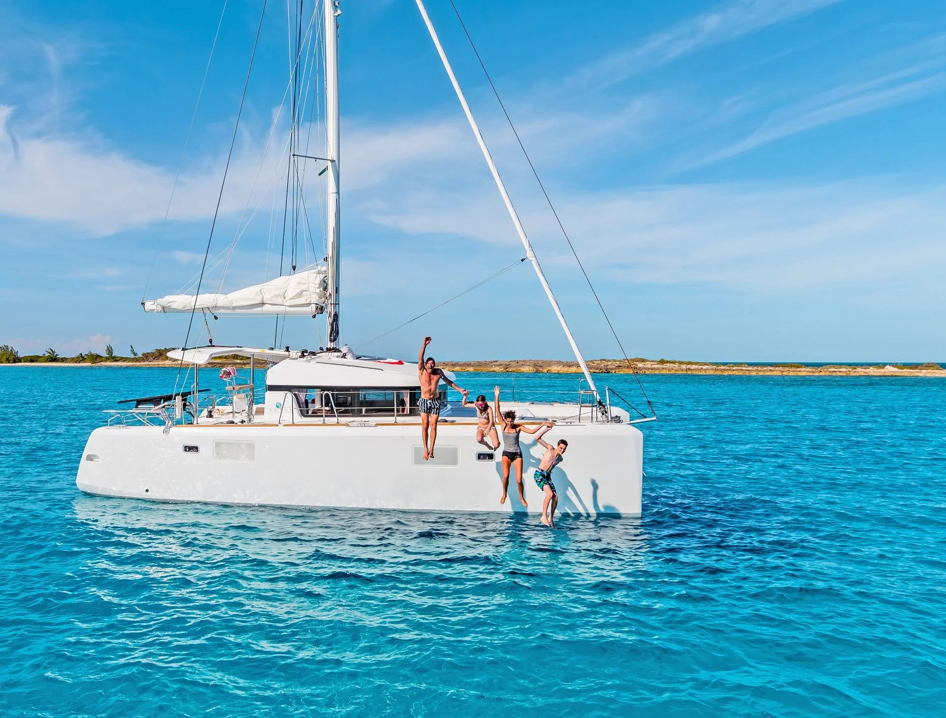 Semi-private catamaran cruise in Santorini with guests swimming in clear blue waters