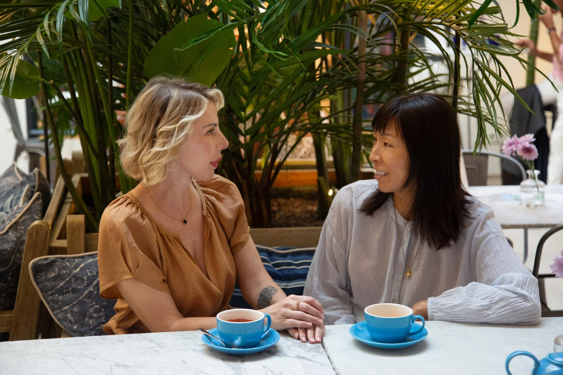 Two women talking over tea, representing ongoing monthly coaching support