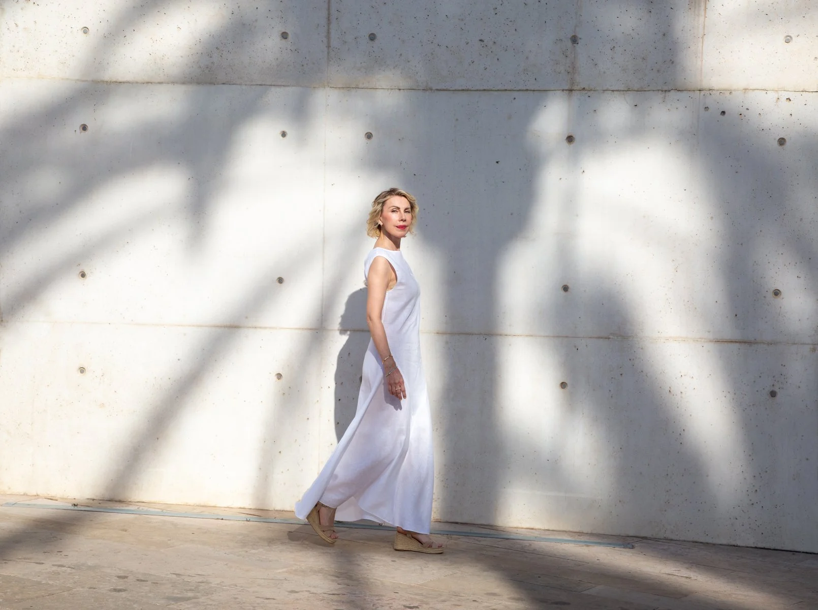 Ingrid, life coach for women over 40, walking confidently outdoors in a white dress