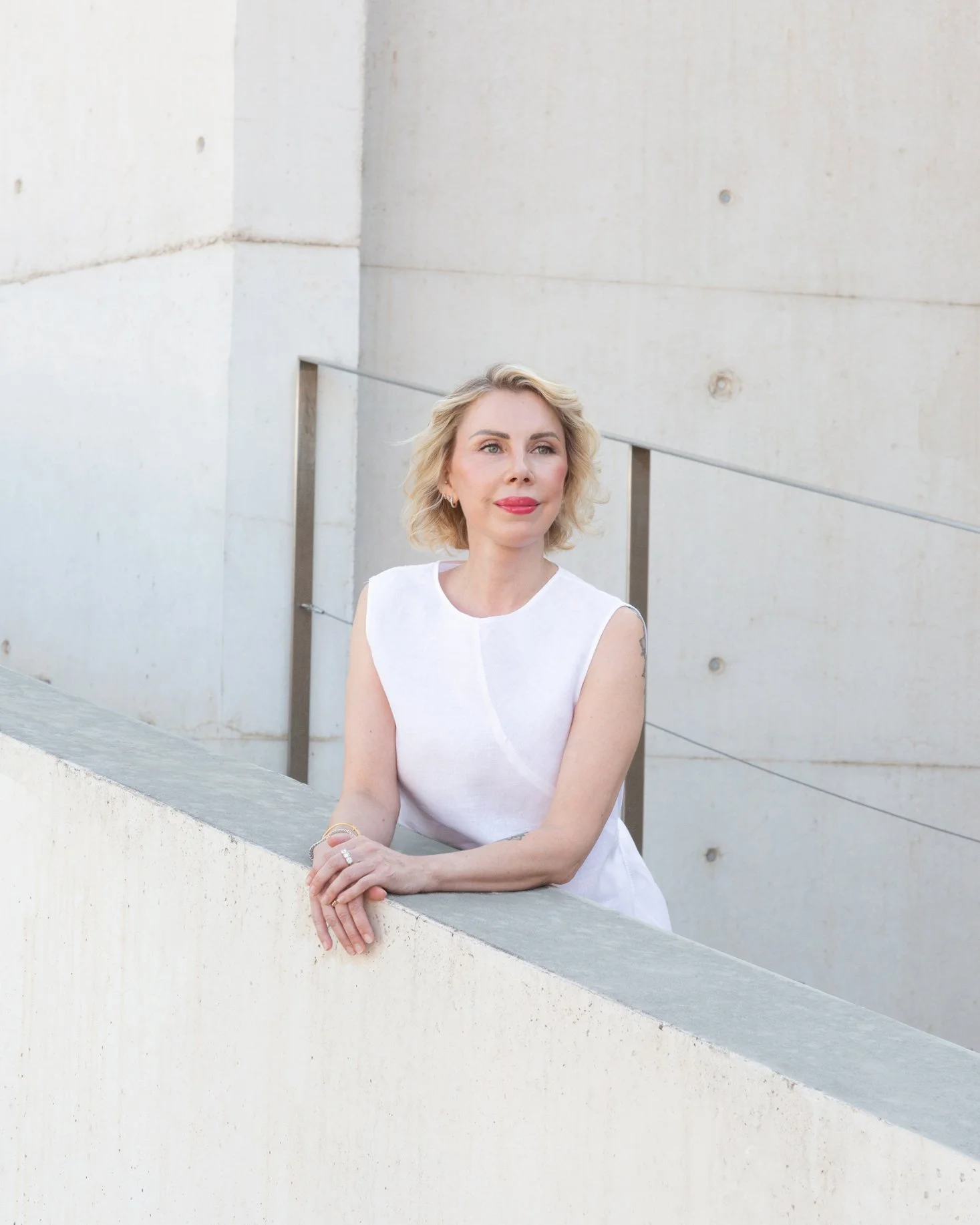 Ingrida Pojemiatskas, certified life coach, standing against a concrete wall