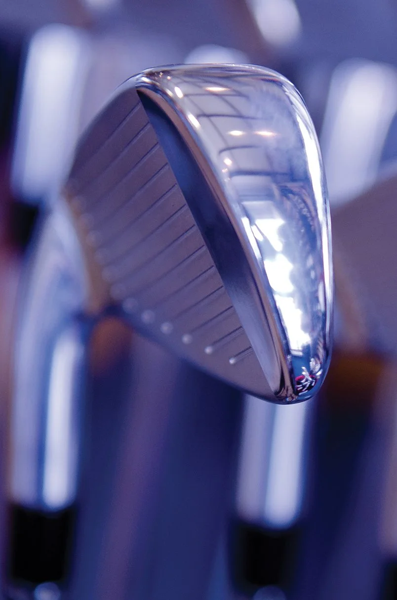 Close-up of a golf club's head, showing its shiny metallic surface and grooves.