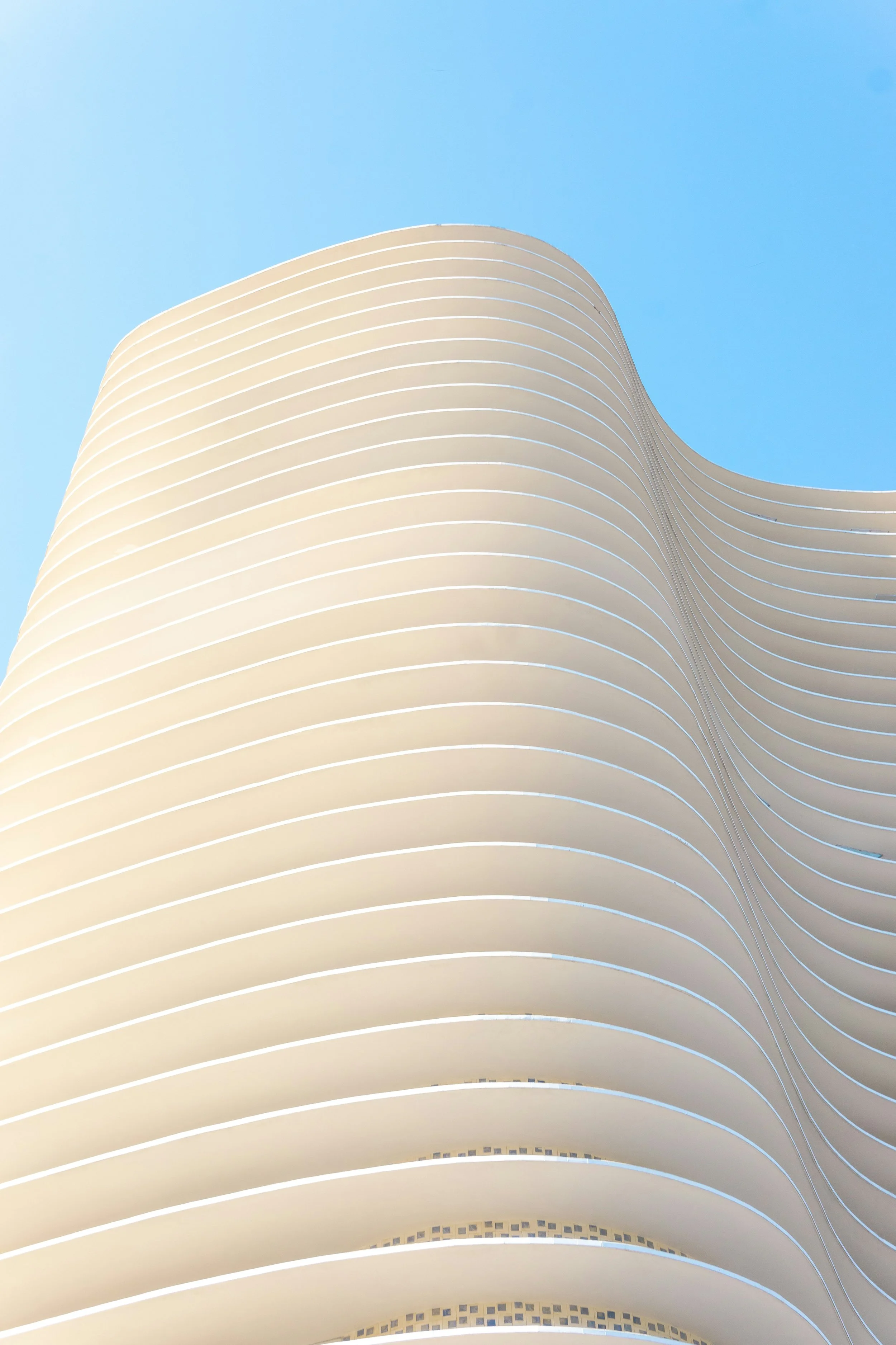 Ein modernes Gebäude mit geschwungenen weißen Linien gegen einen blauen Himmel.