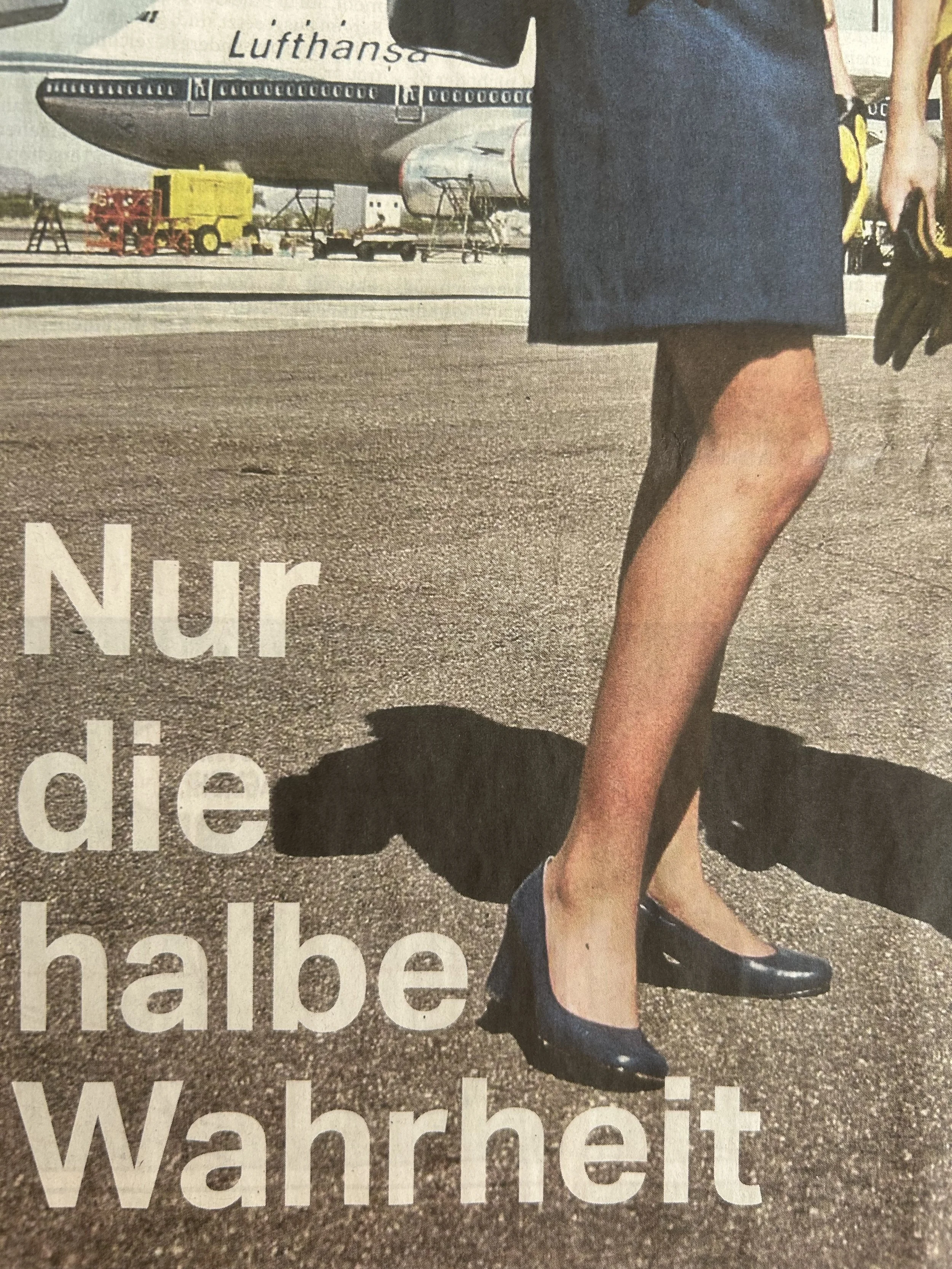 Ein Flugzeug steht auf einem Flughafen. Im Vordergrund ist eine Person in einem schwarzen Rock und mit schwarzen Schuhen zu sehen, die auf dem Boden sitzt, während sie eine andere Person an den Beinen hält.