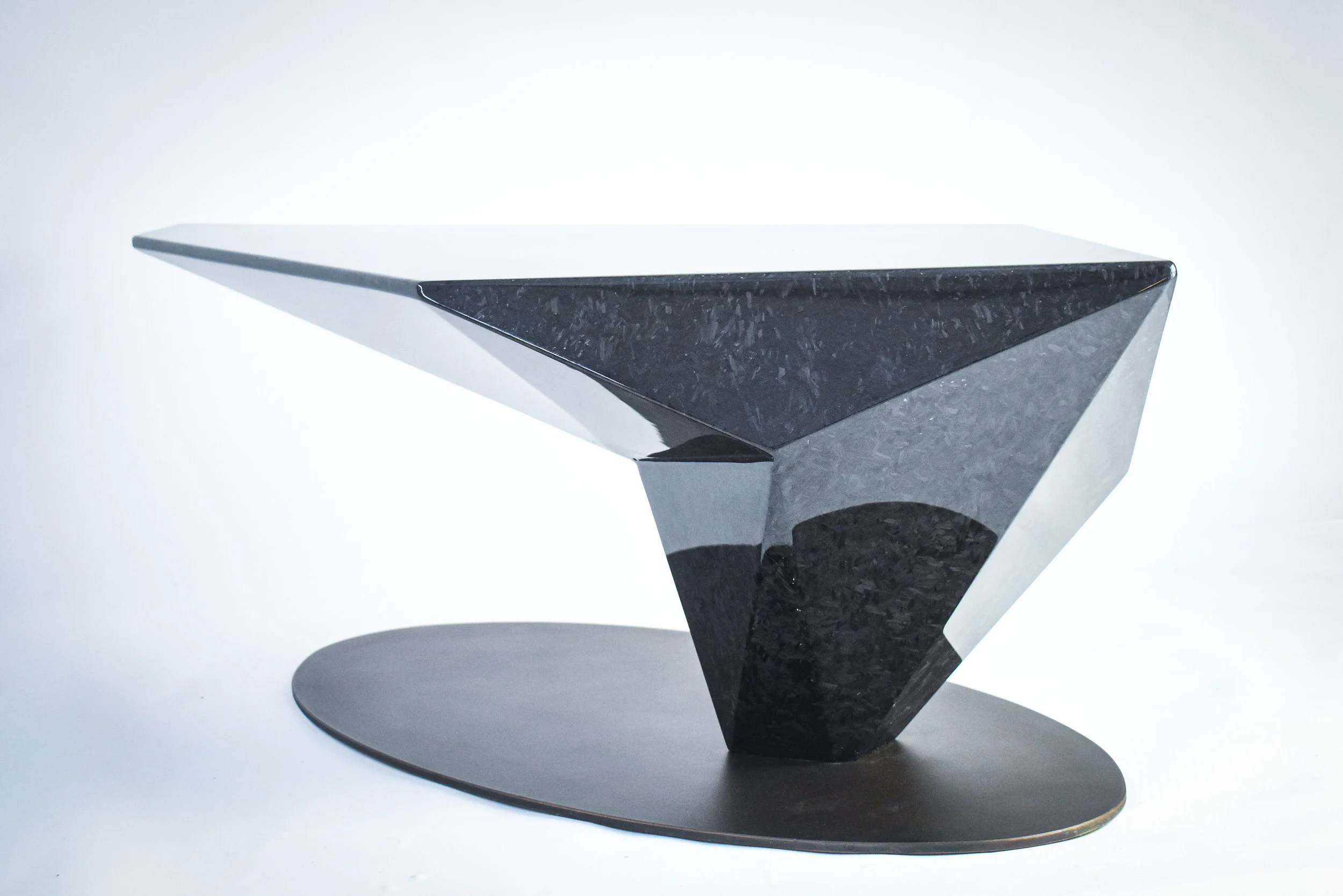 Modern black geometric table with angled design on a white background