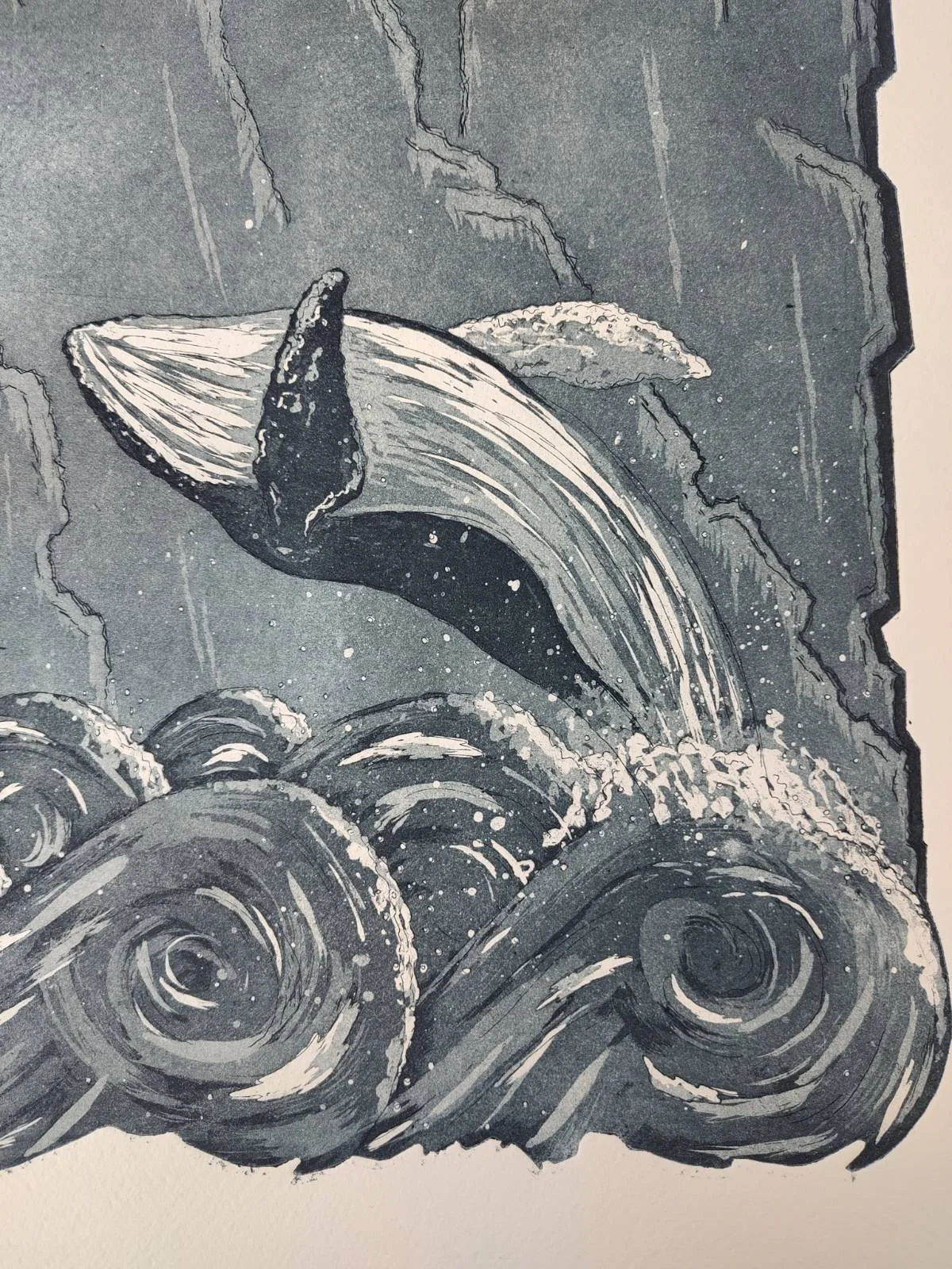 corner of a large etching print with a whale breaching