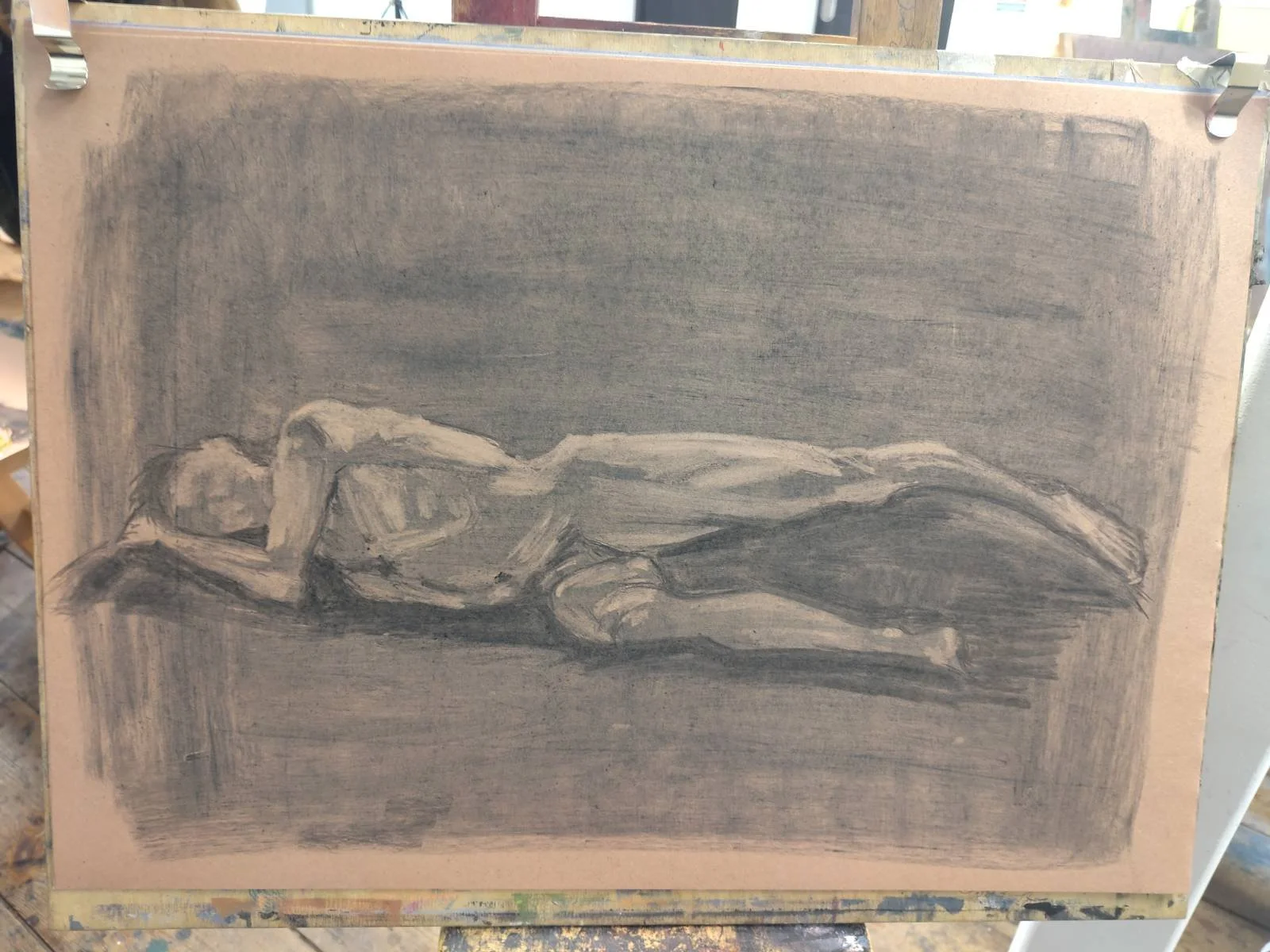 charcoal tonal sketch of man lying on side