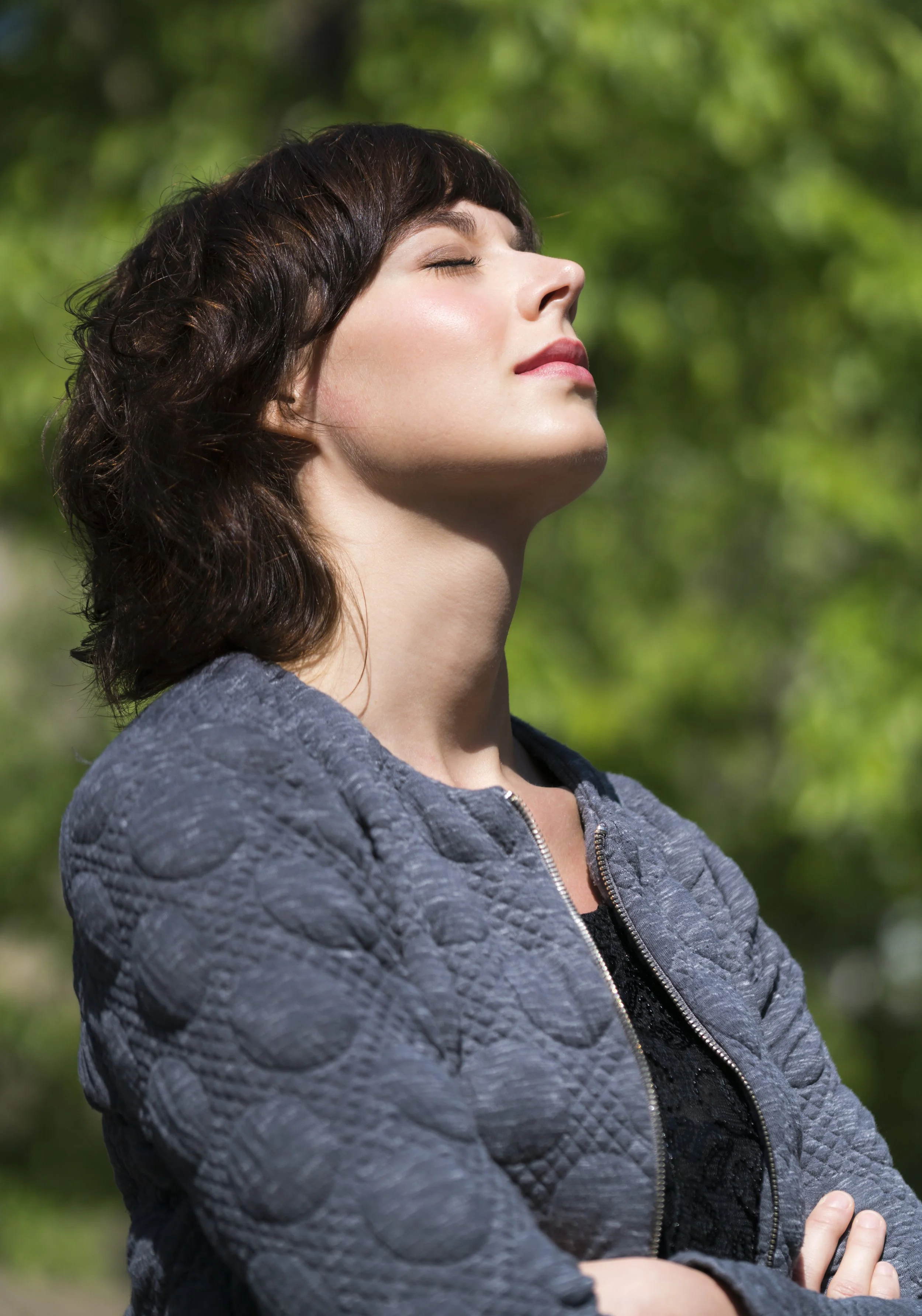 Woman practising deep breathing outdoors in nature to support lymphatic circulation and reduce puffiness after winter